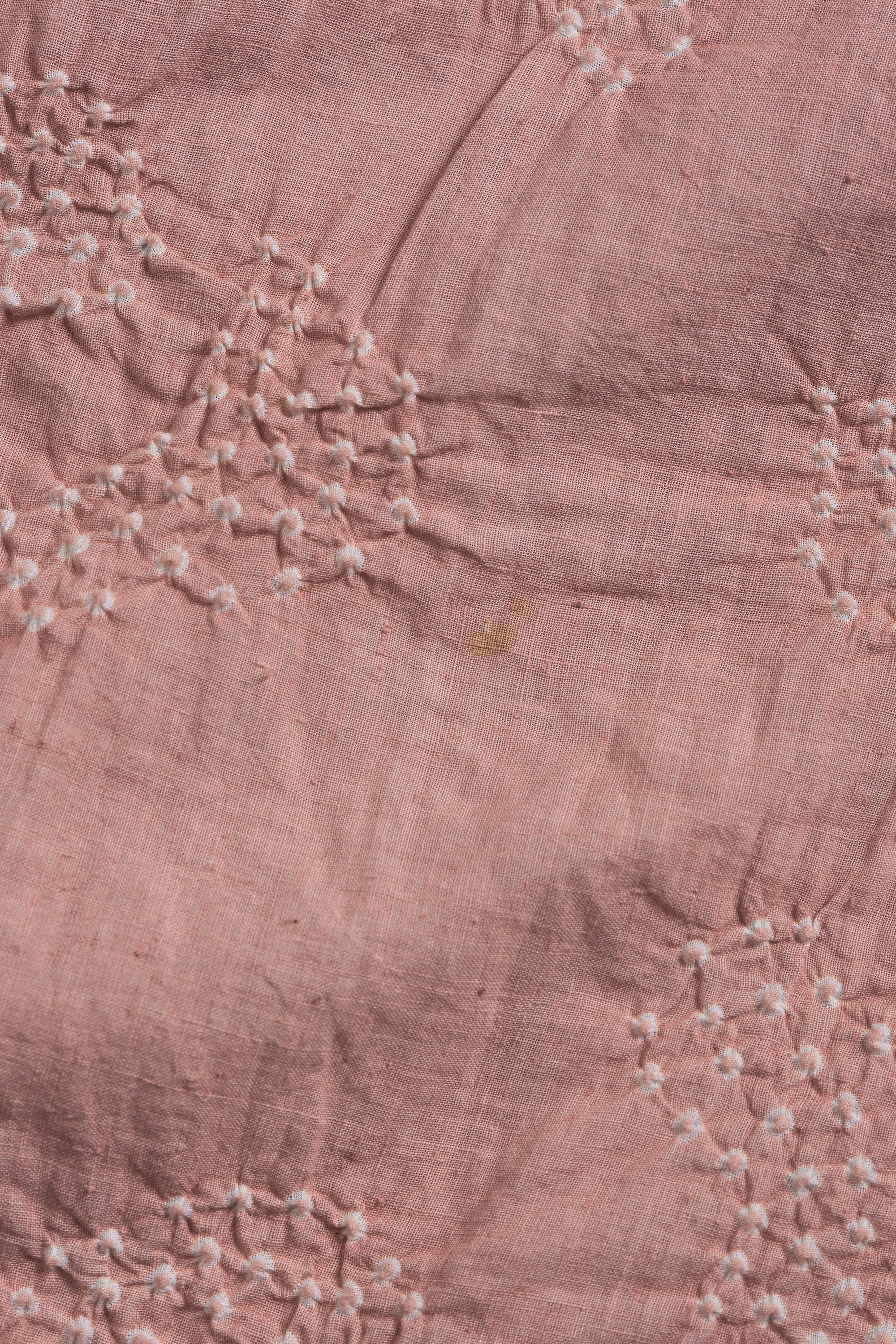 Close-up of pink fabric with white embroidery