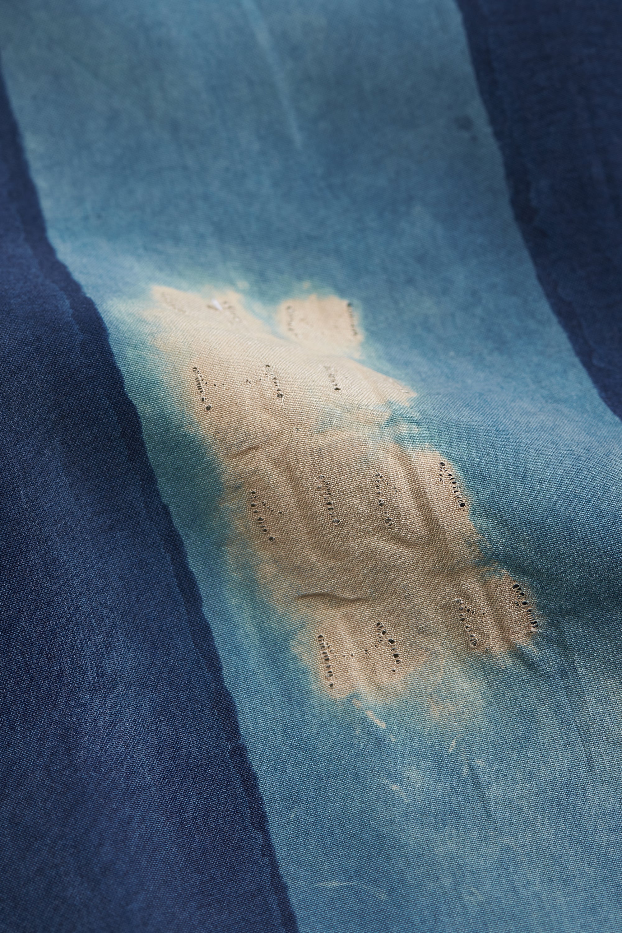 Blue fabric with a large yellowish stain