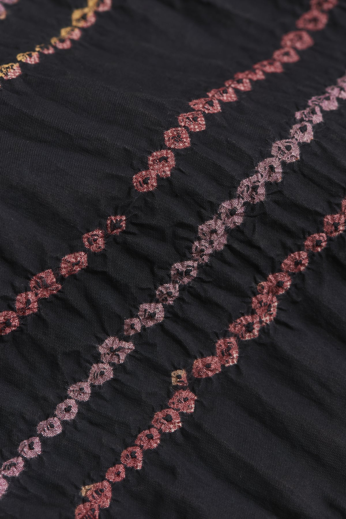 Close-up of black fabric with pink floral embroidery