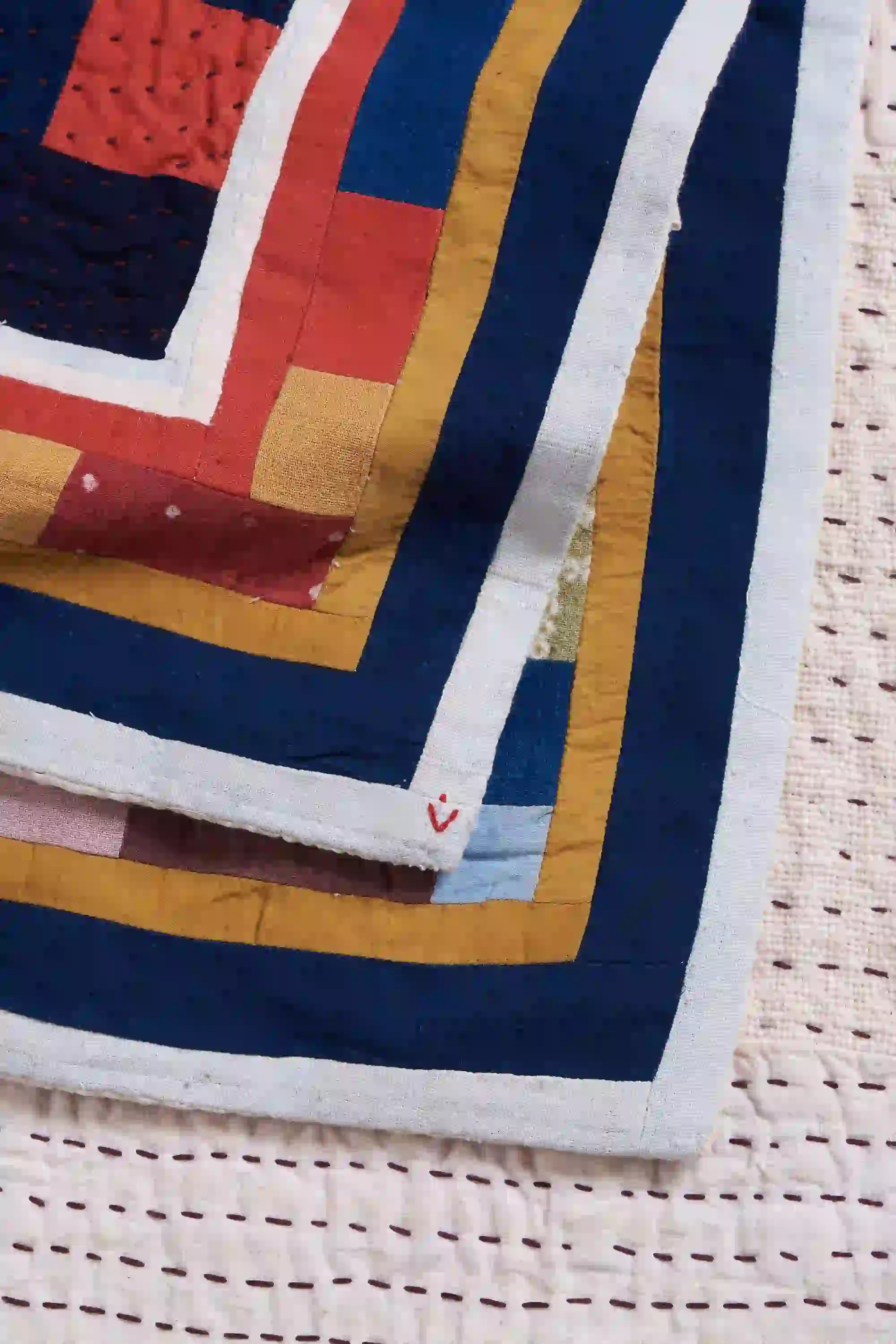 Colorful quilt with geometric pattern on a woven surface