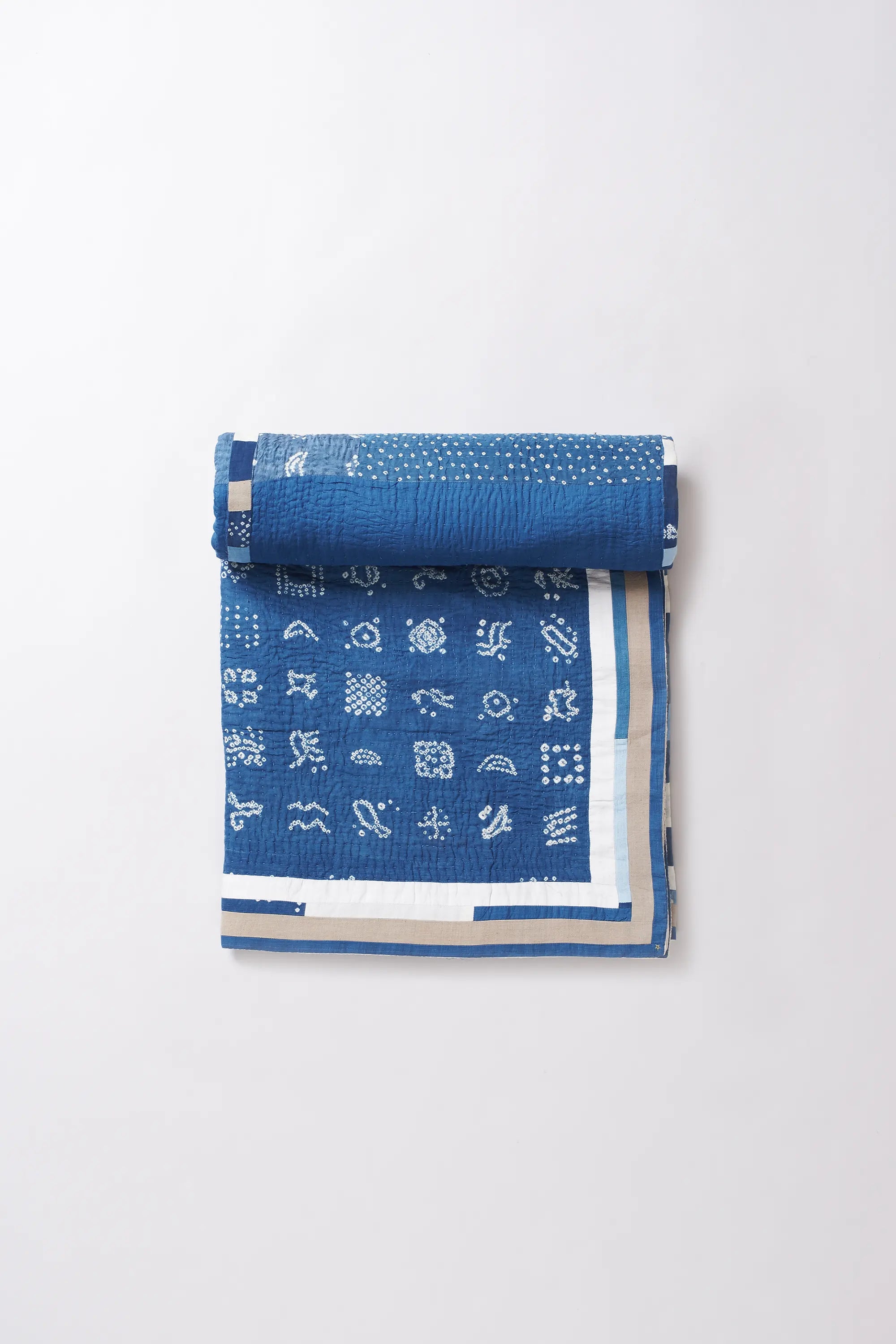 Rolled-up blue fabric with white patterns on a white background