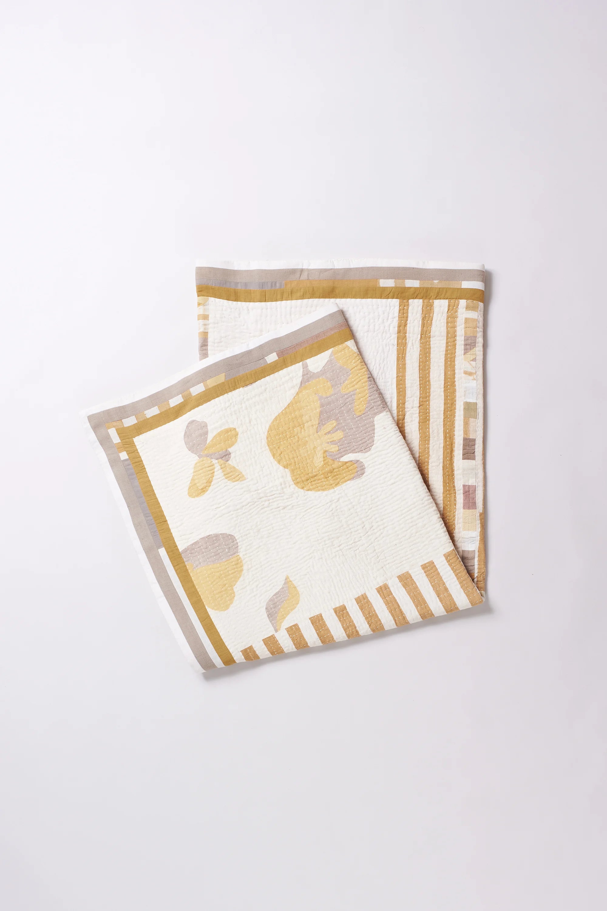 Folded fabric with white and yellow pattern on a white background