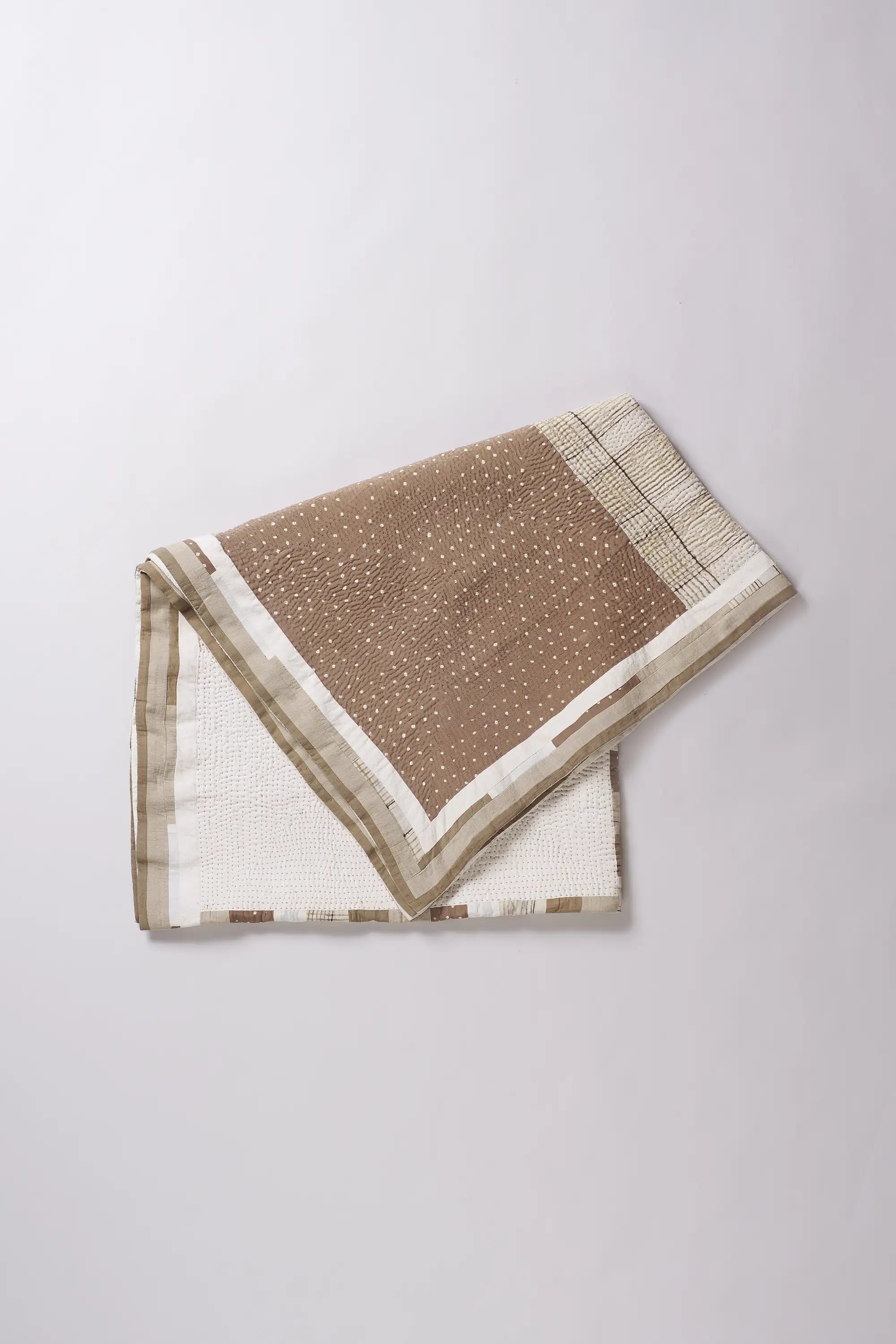 Folded fabric with white and brown pattern on a white background