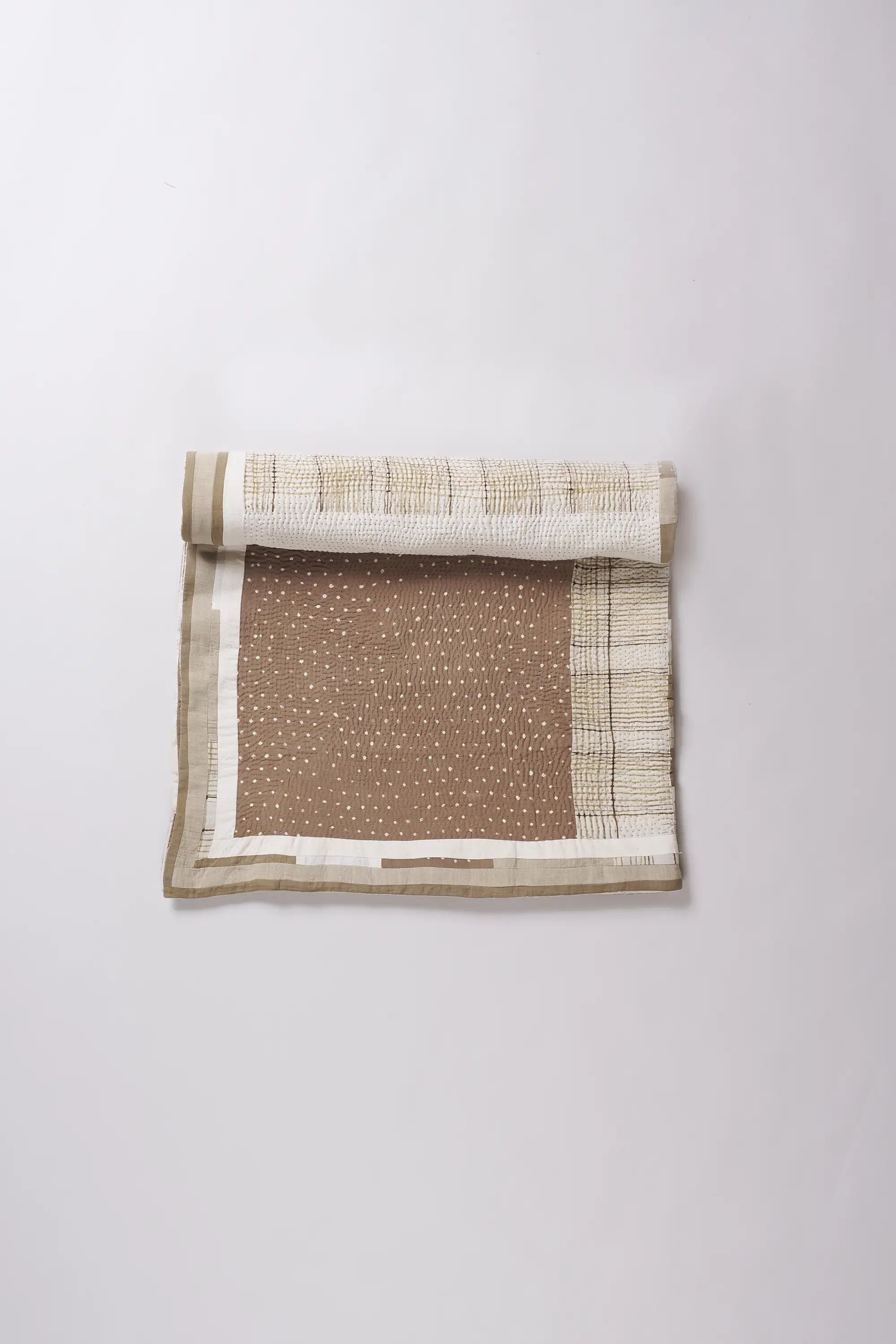 Folded fabric with white and brown pattern on a white background