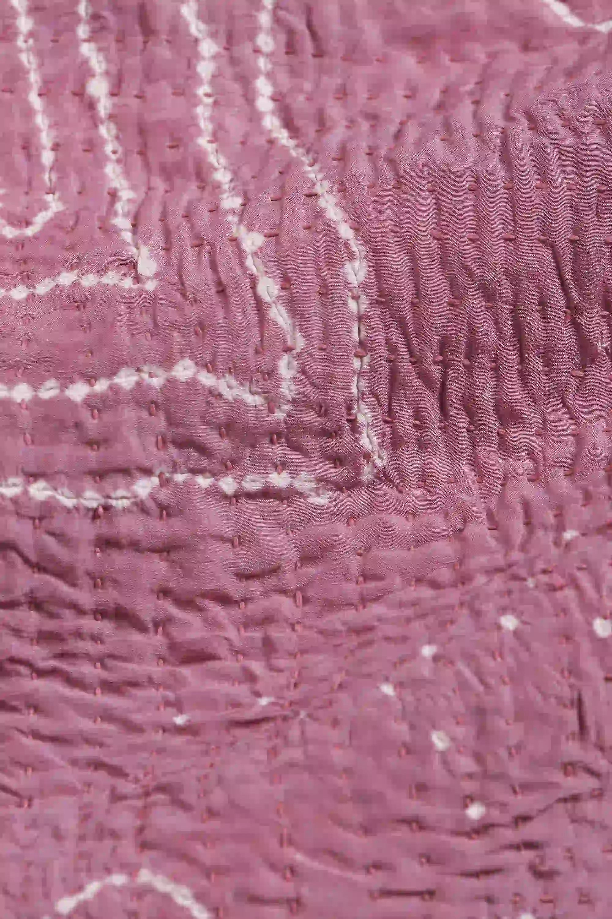 Close-up of pink fabric with white embroidery