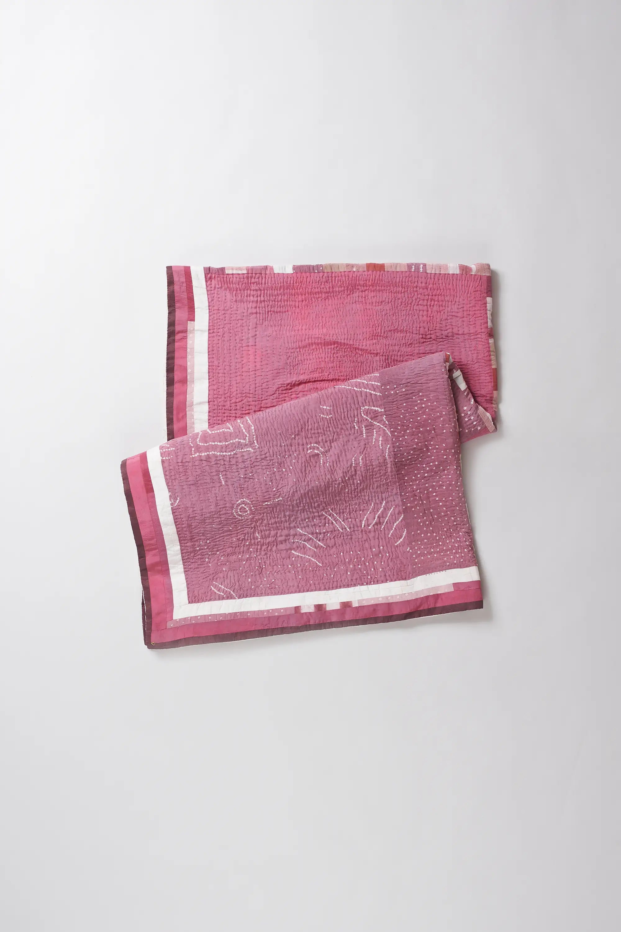 Two pink patterned towels on a white background