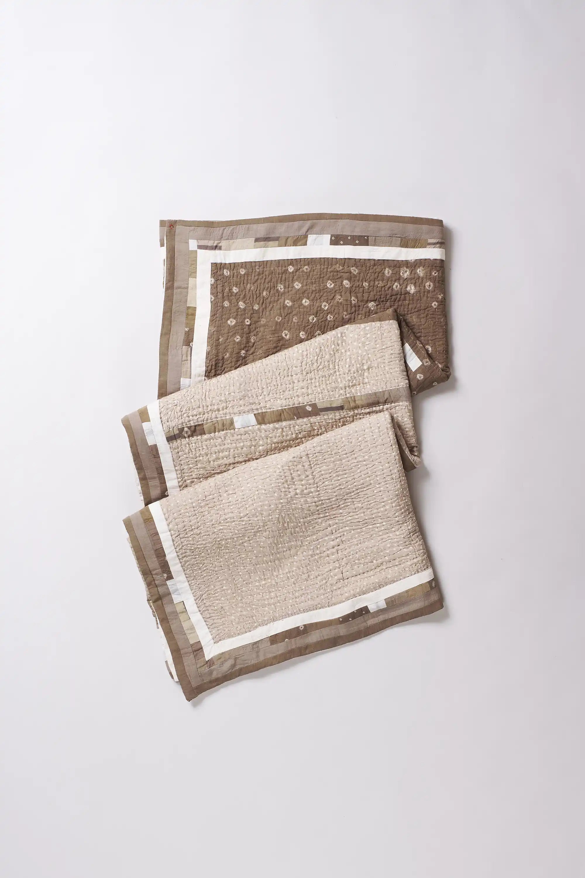 Set of three folded towels with different patterns on a white background