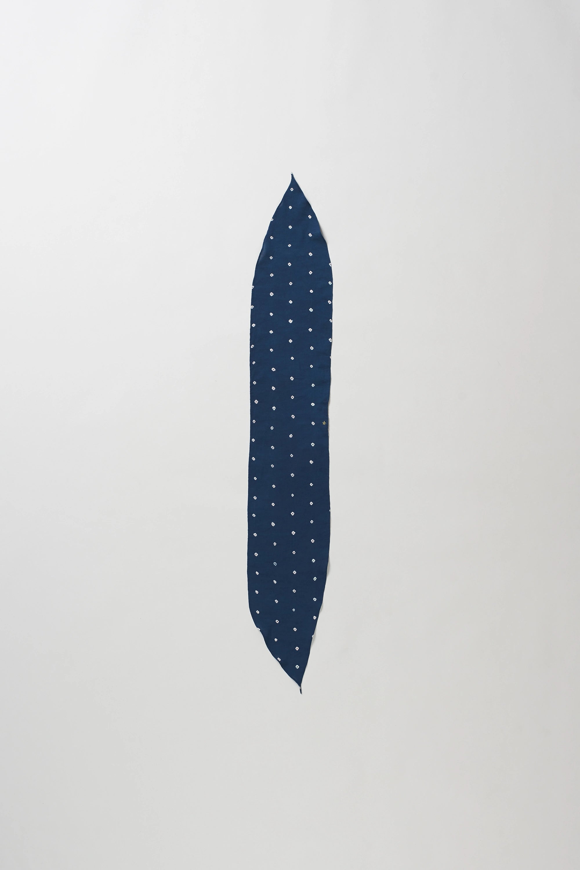 A indigo bandana with a white polka-dot pattern, displayed vertically against a plain light grey background.