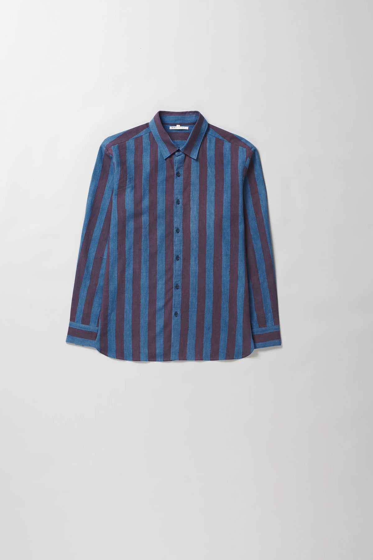 A long-sleeve button-up shirt with vertical stripes in blue and dark red, laid flat against a light grey background.