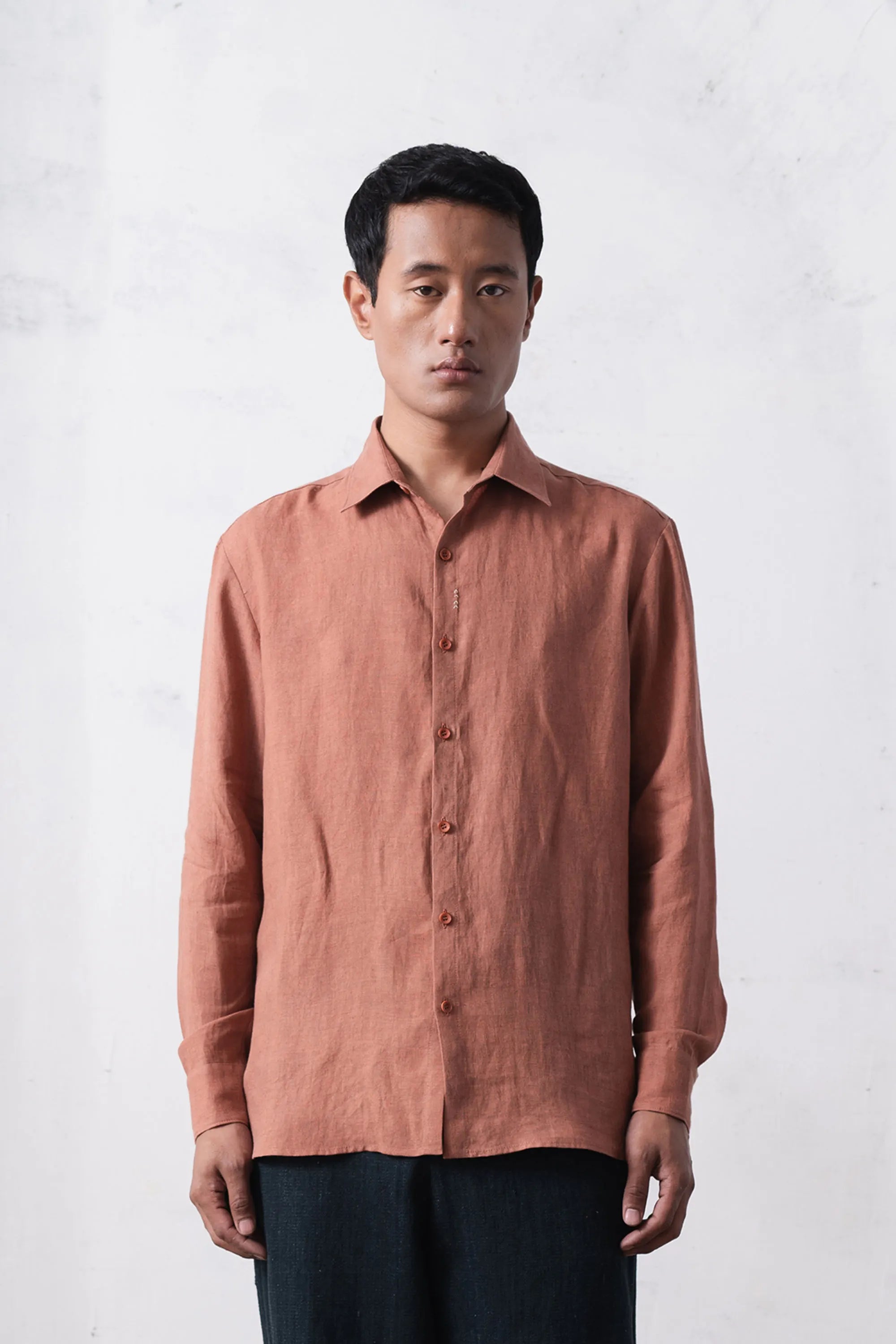 A man wearing orange rust linen shirt
