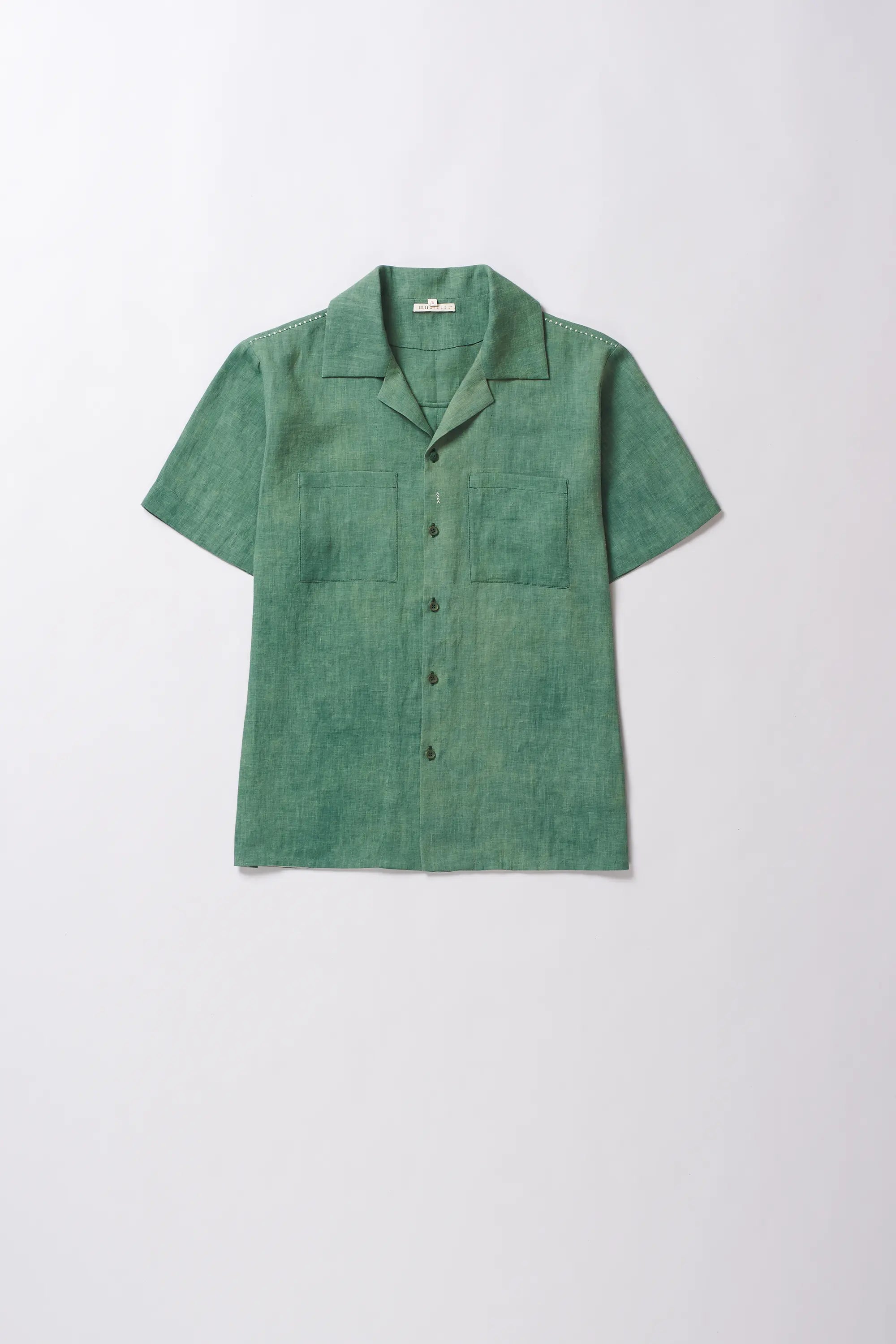 Green short-sleeve shirt on a light grey background