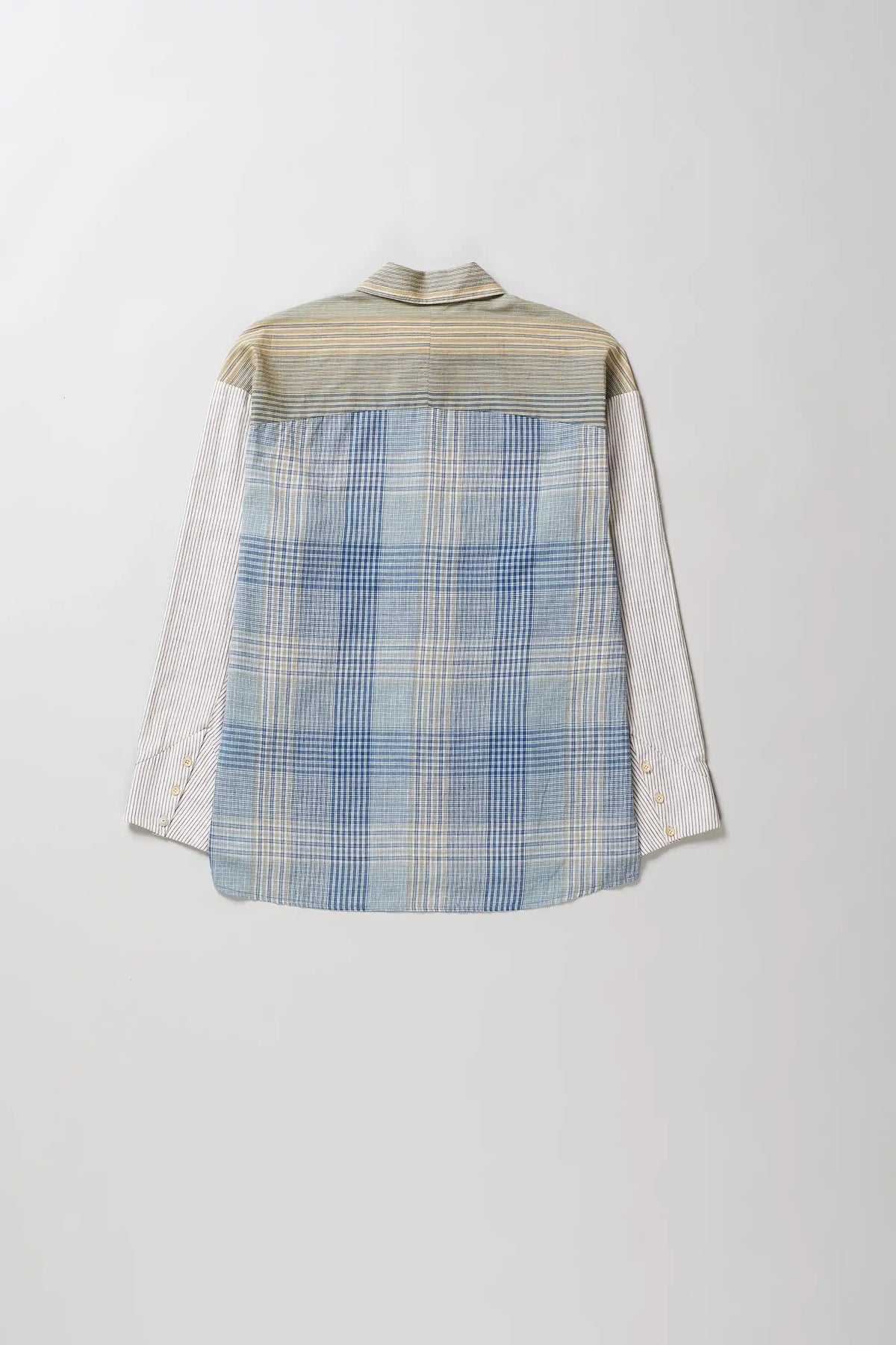 Back shot of long-sleeve button-up shirt with a vertical striped pattern in beige, blue, and yellow, featuring solid light-colored sleeves, laid flat against a light grey background.