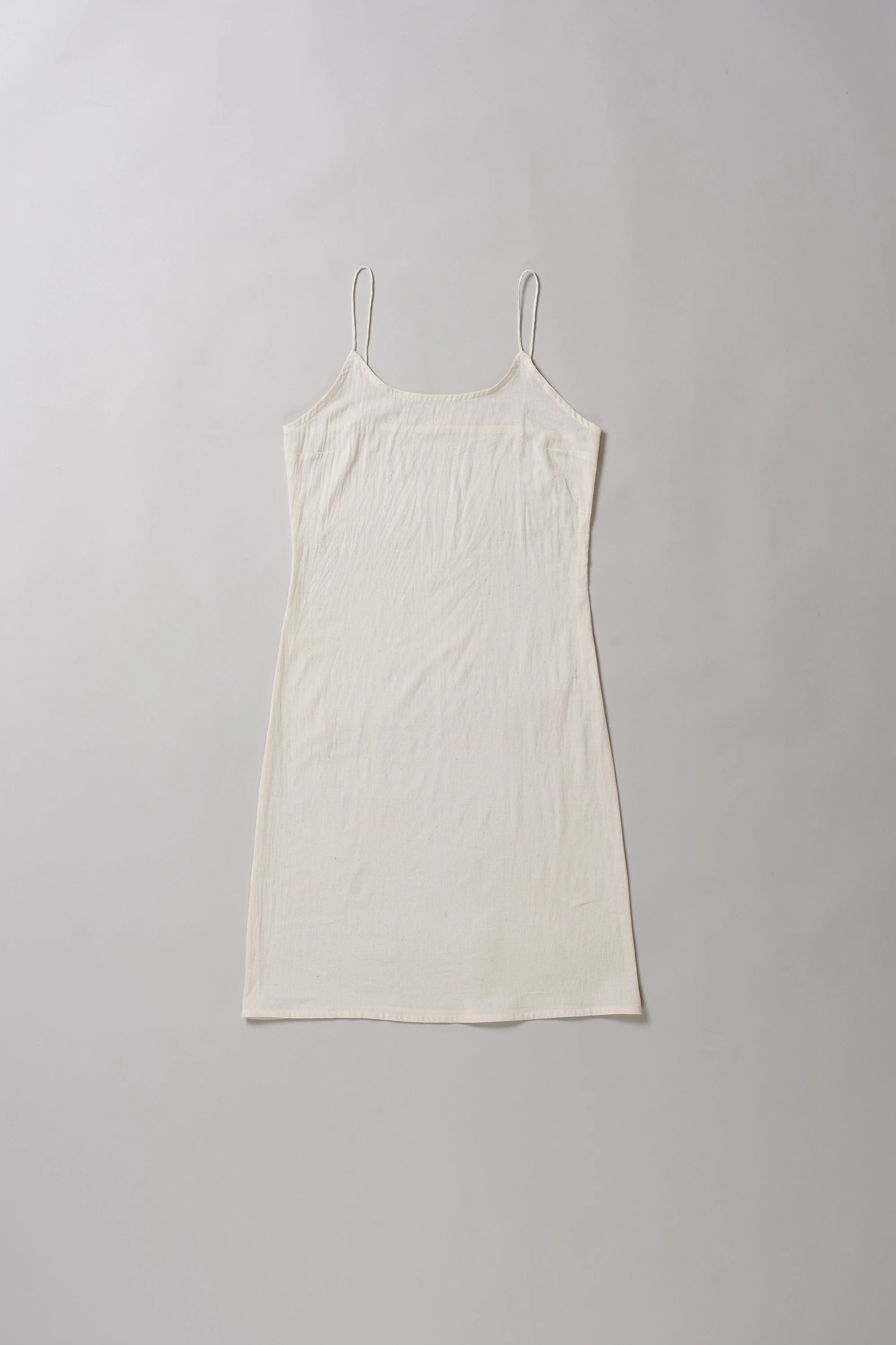 Ecru slip dress on a grey background
