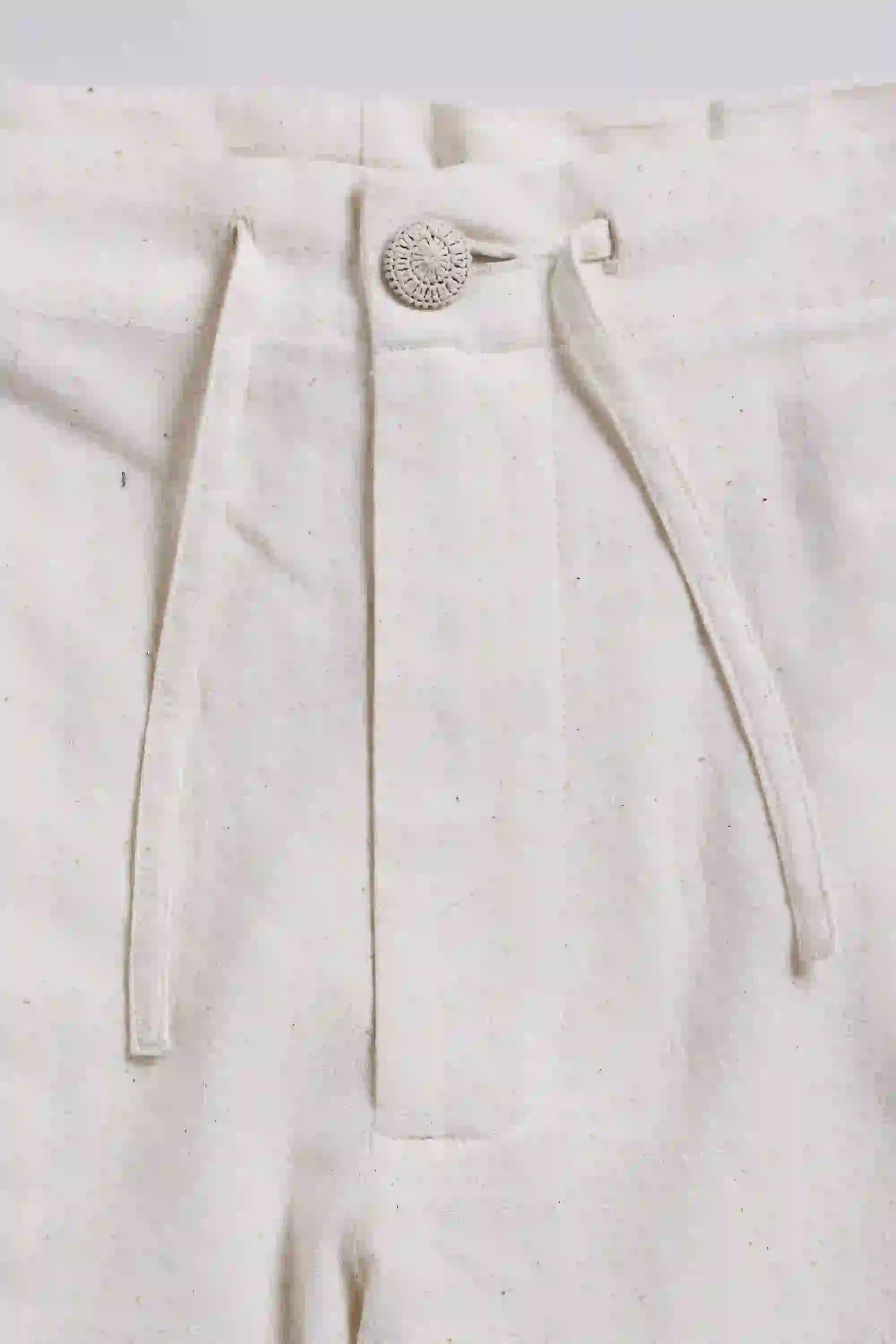 Close-up of a white pants with a button on a light gray background