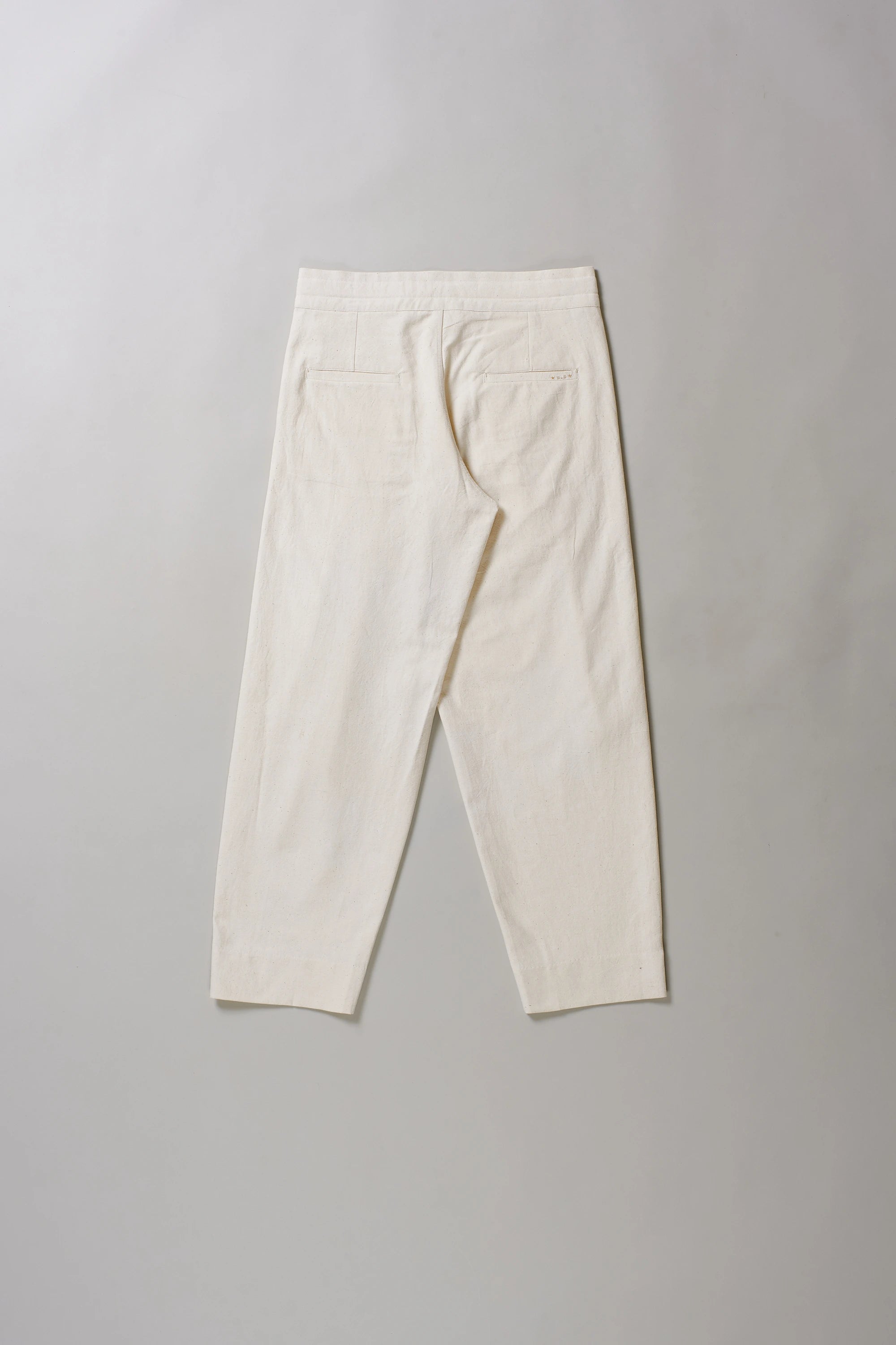 Back image of ecru pants on a grey background