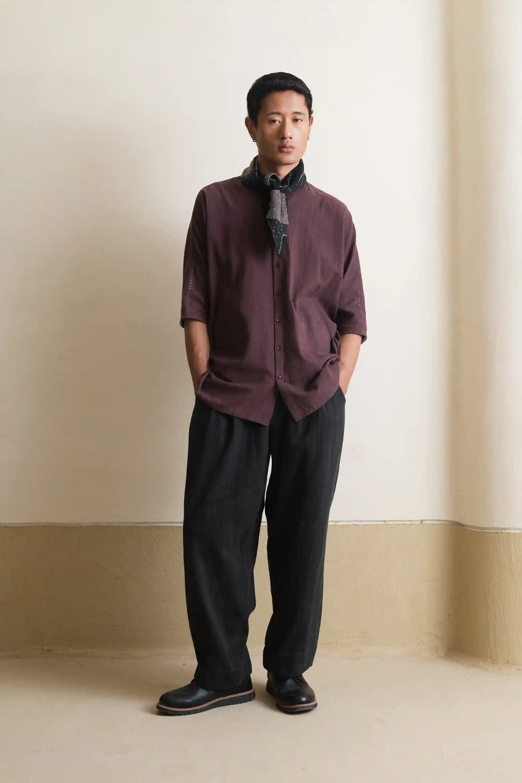 A man wearing purple red shirt with bandana