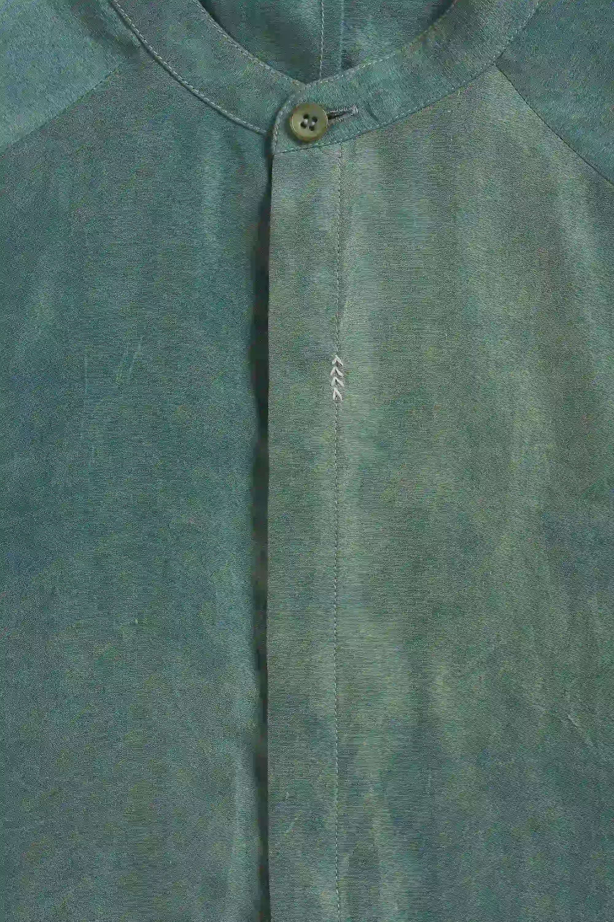 Close-up of a fabric with a button and hand detailing