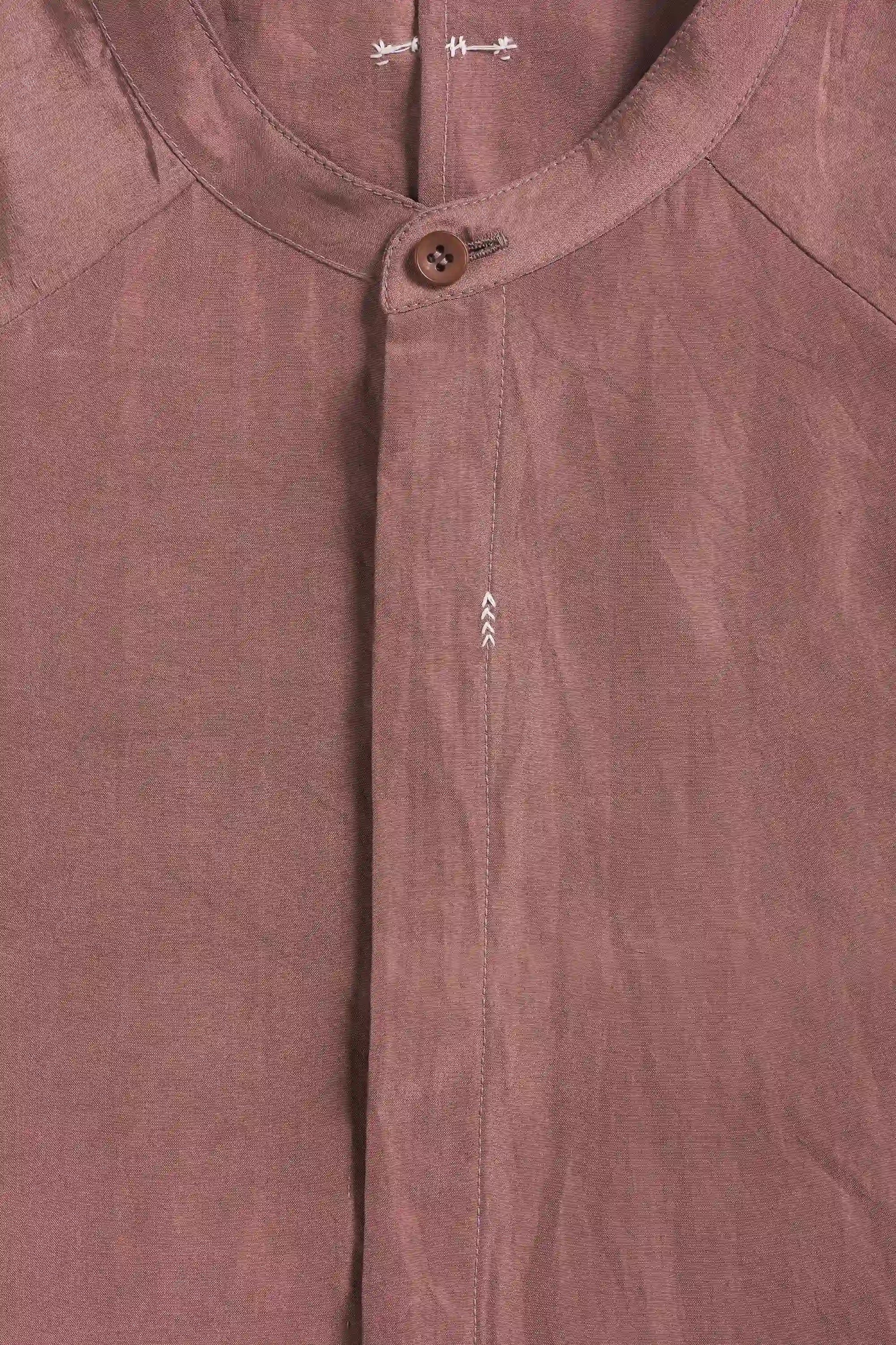 Close-up of a garment with a button and hand detailing