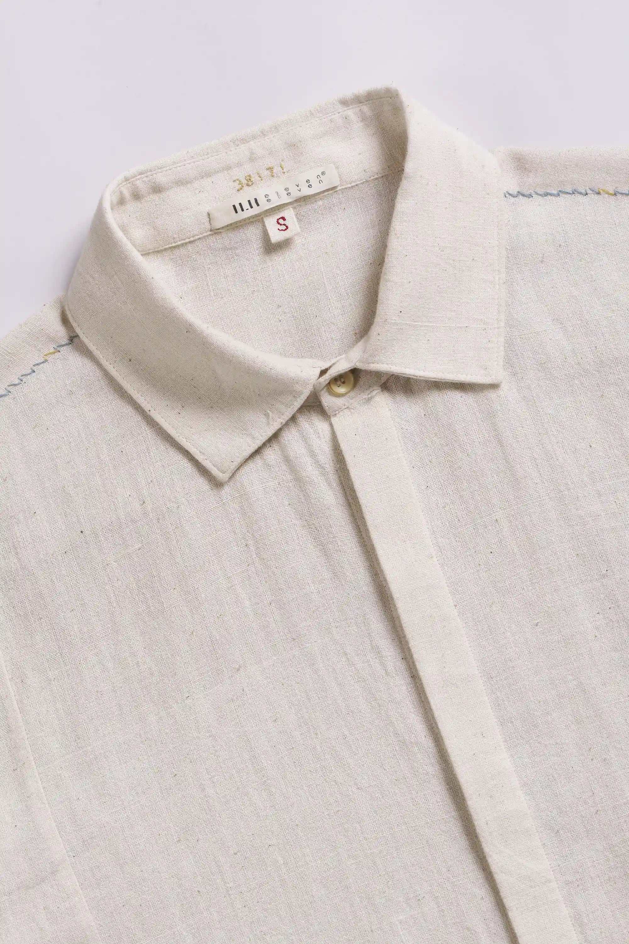 Close-up of a ecru shirt with a collar on a light grey background