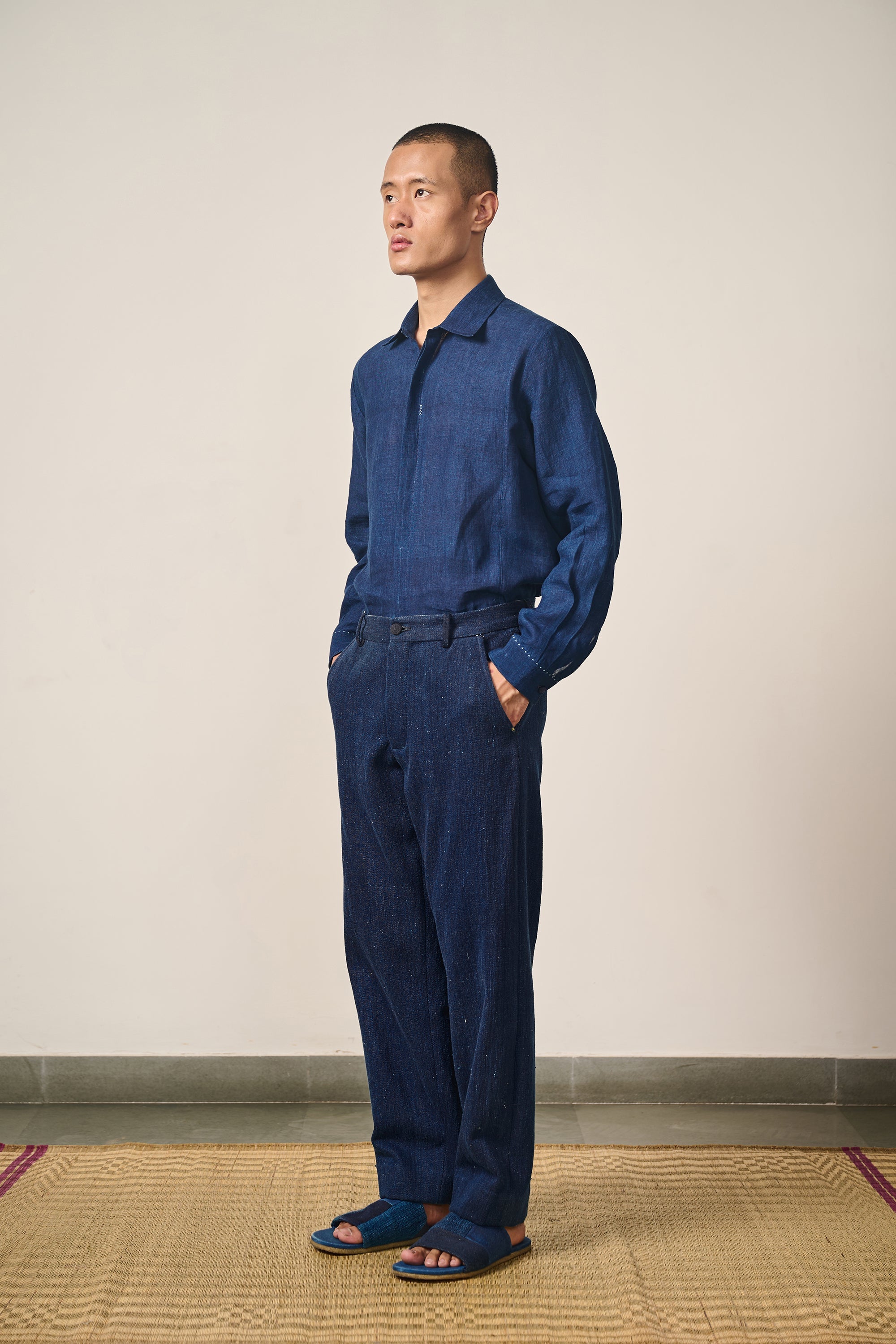 A side shot of a man wearing indigo shirt