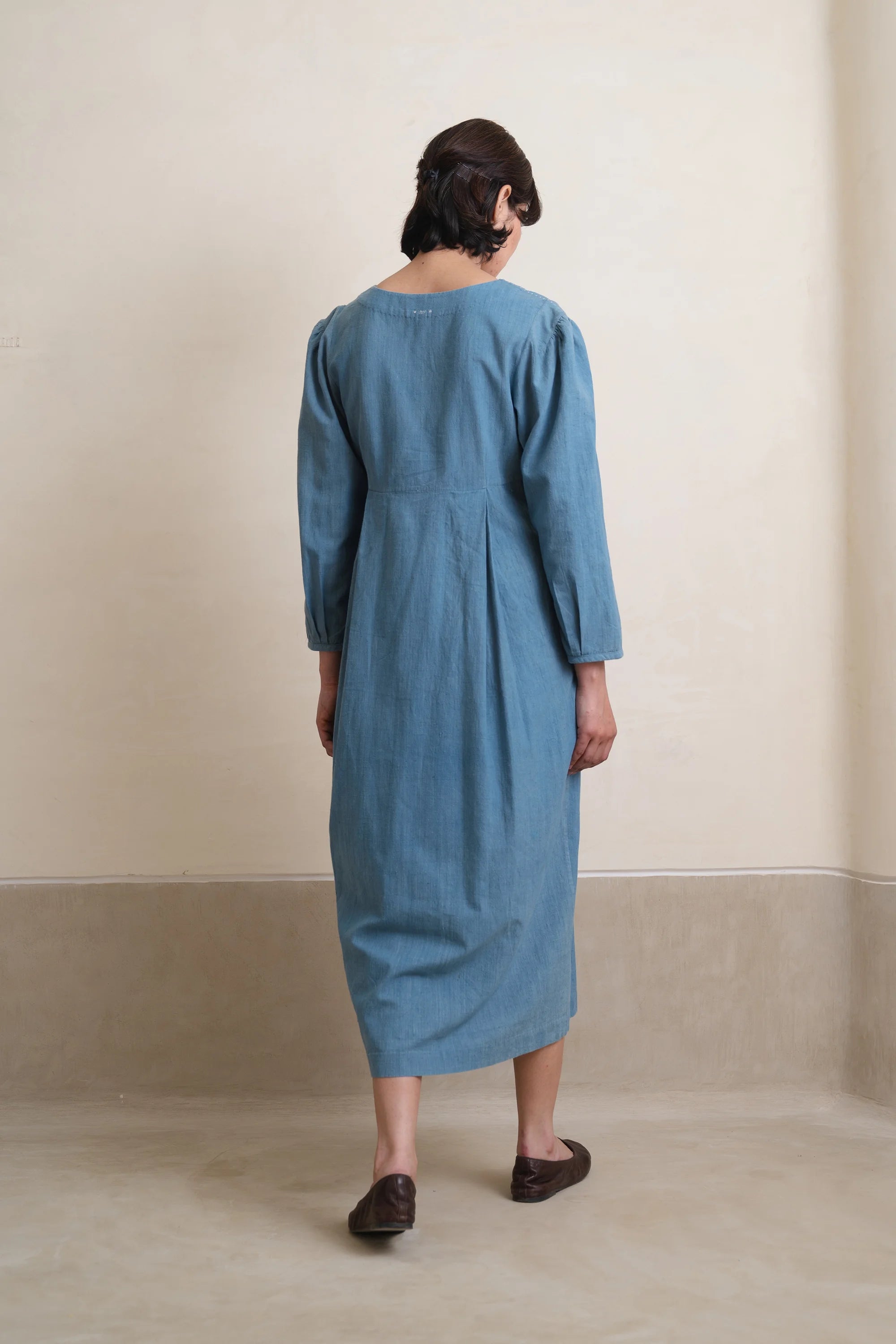 A back shot of a woman wearing powder blue dress