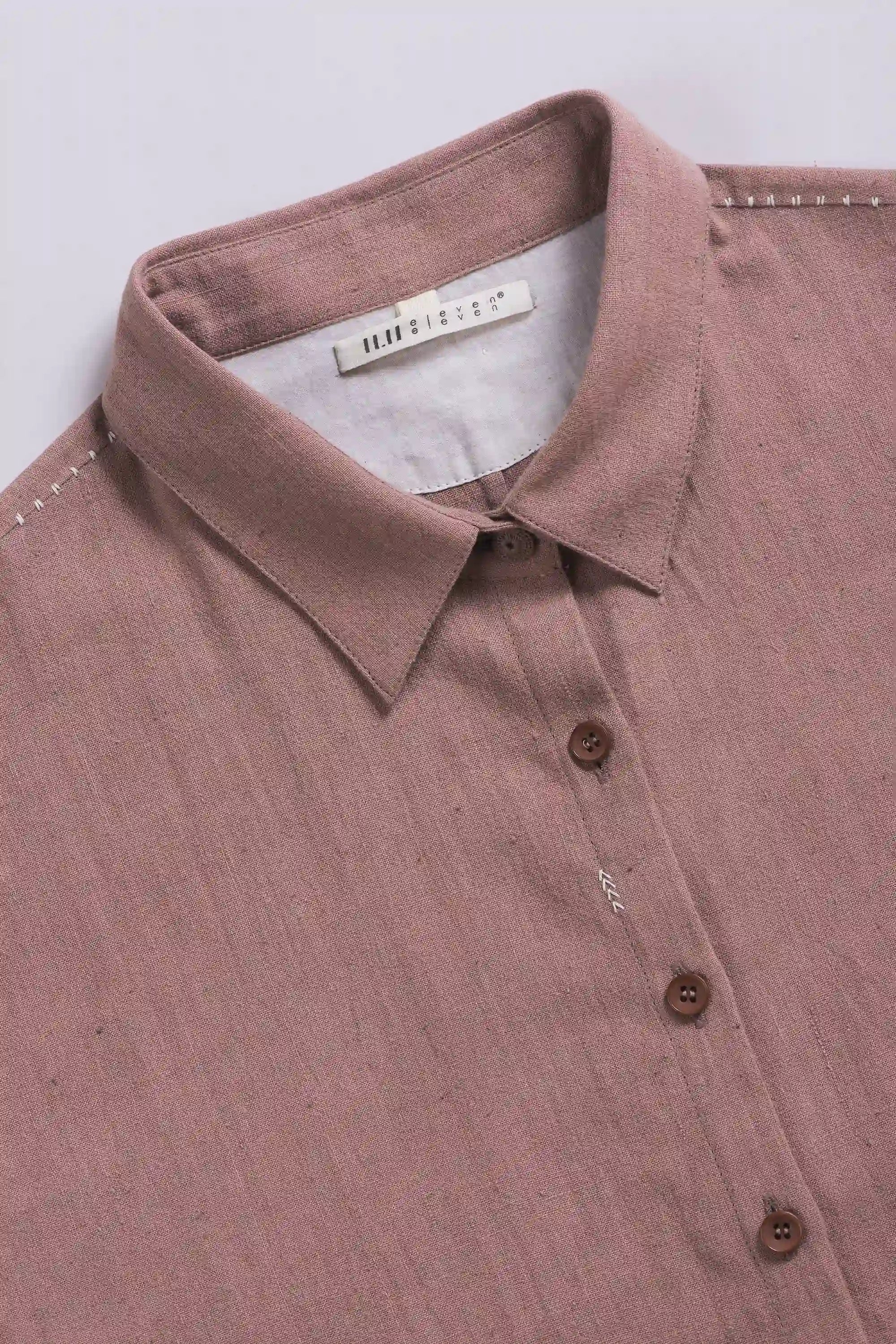 Close-up of a shirt with collar and buttons on a light grey background
