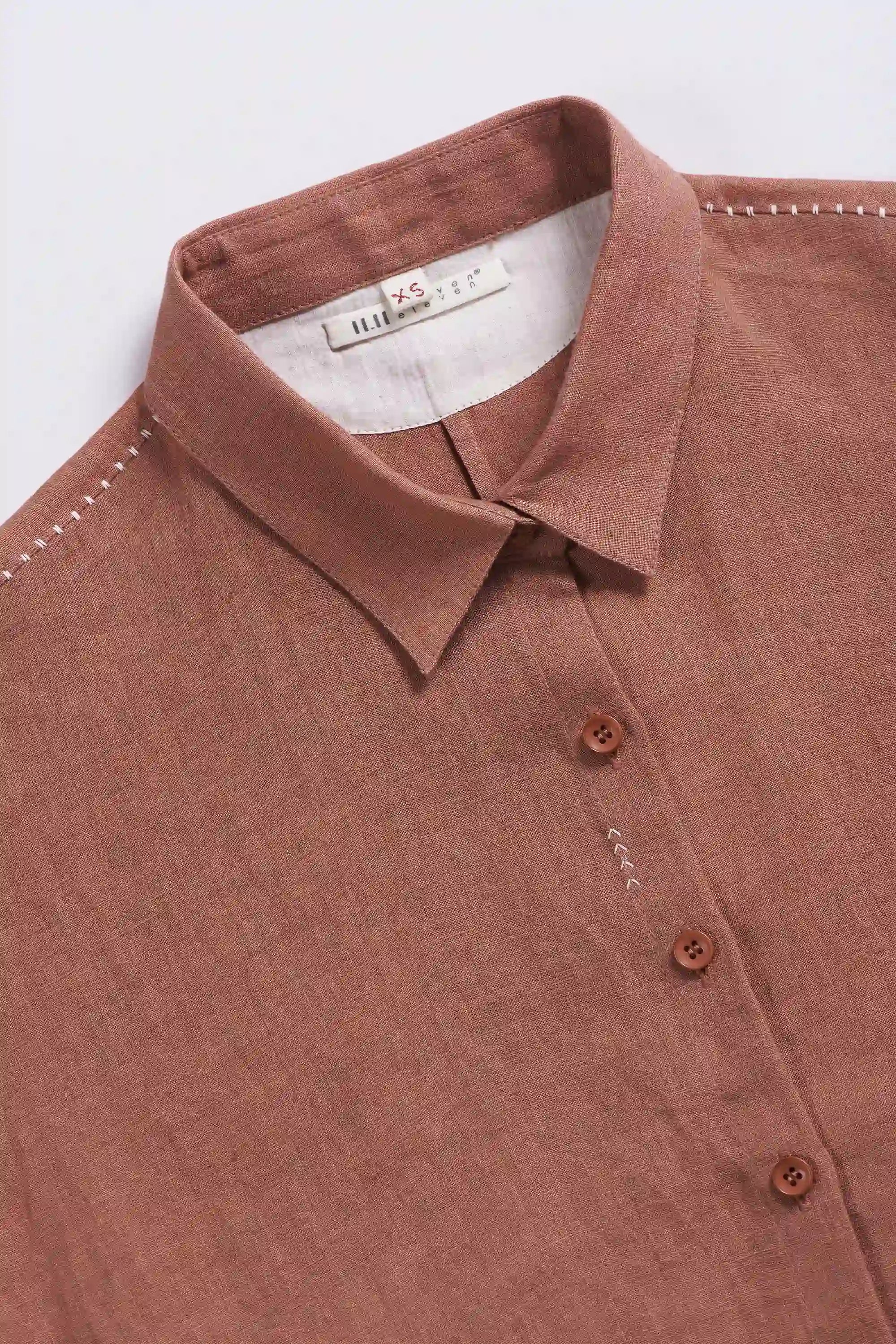 Orange rust shirt with collar and buttons on a light grey background