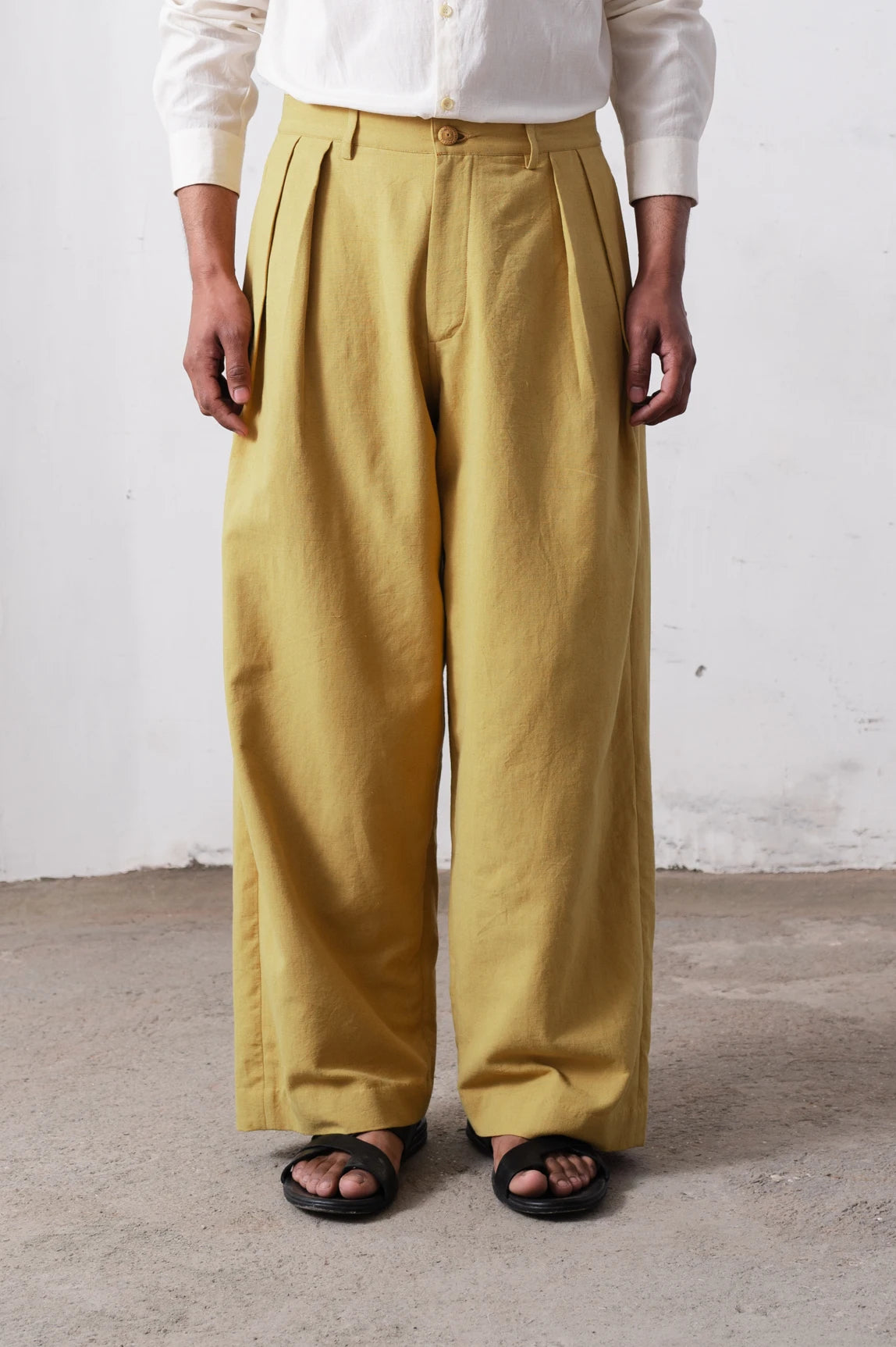 Person wearing ochre yellow wide-leg pants against a light grey background