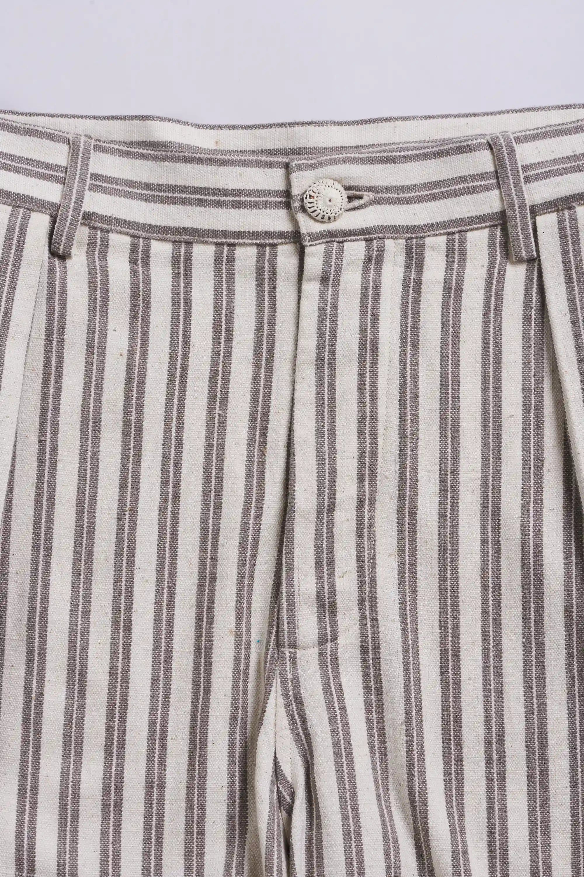 Close-up of a pair of striped pants with a button on a light grey background