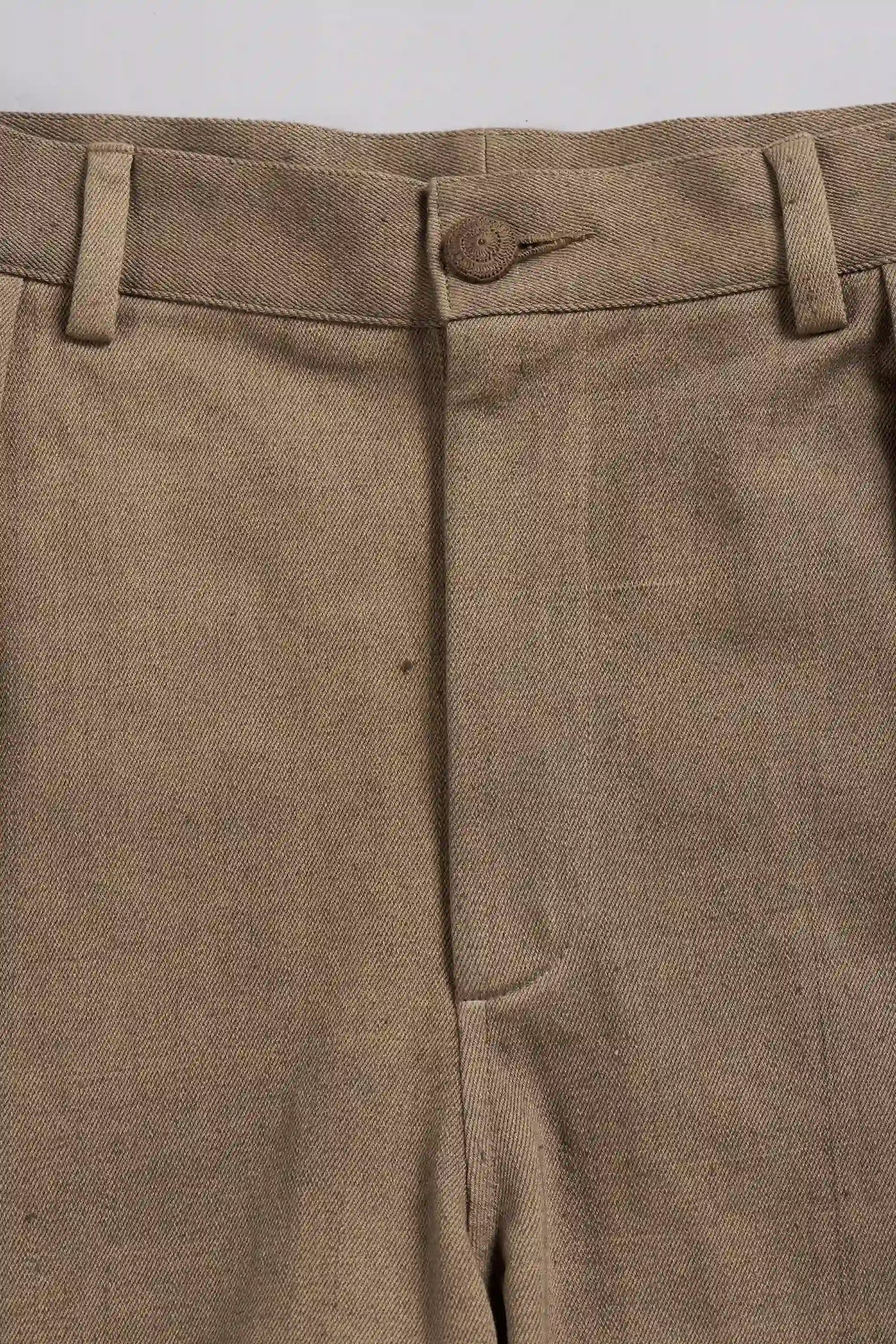 Close-up of the waistband and front fly of a pair of khaki-colored trousers, showing belt loops, a button closure, and the textured woven fabric.
