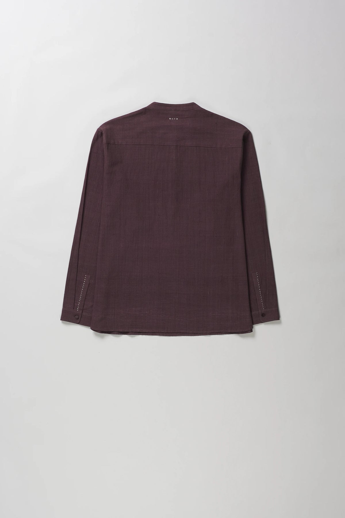A purple red-colored long-sleeve shirt shown from the back, laid flat against a light grey background.