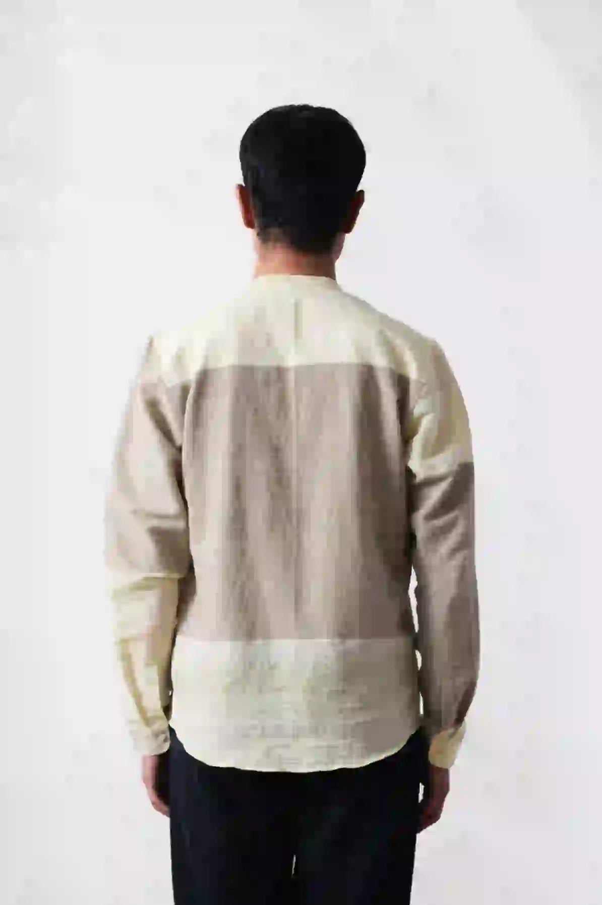 A back shot of man wearing khaki green shirt