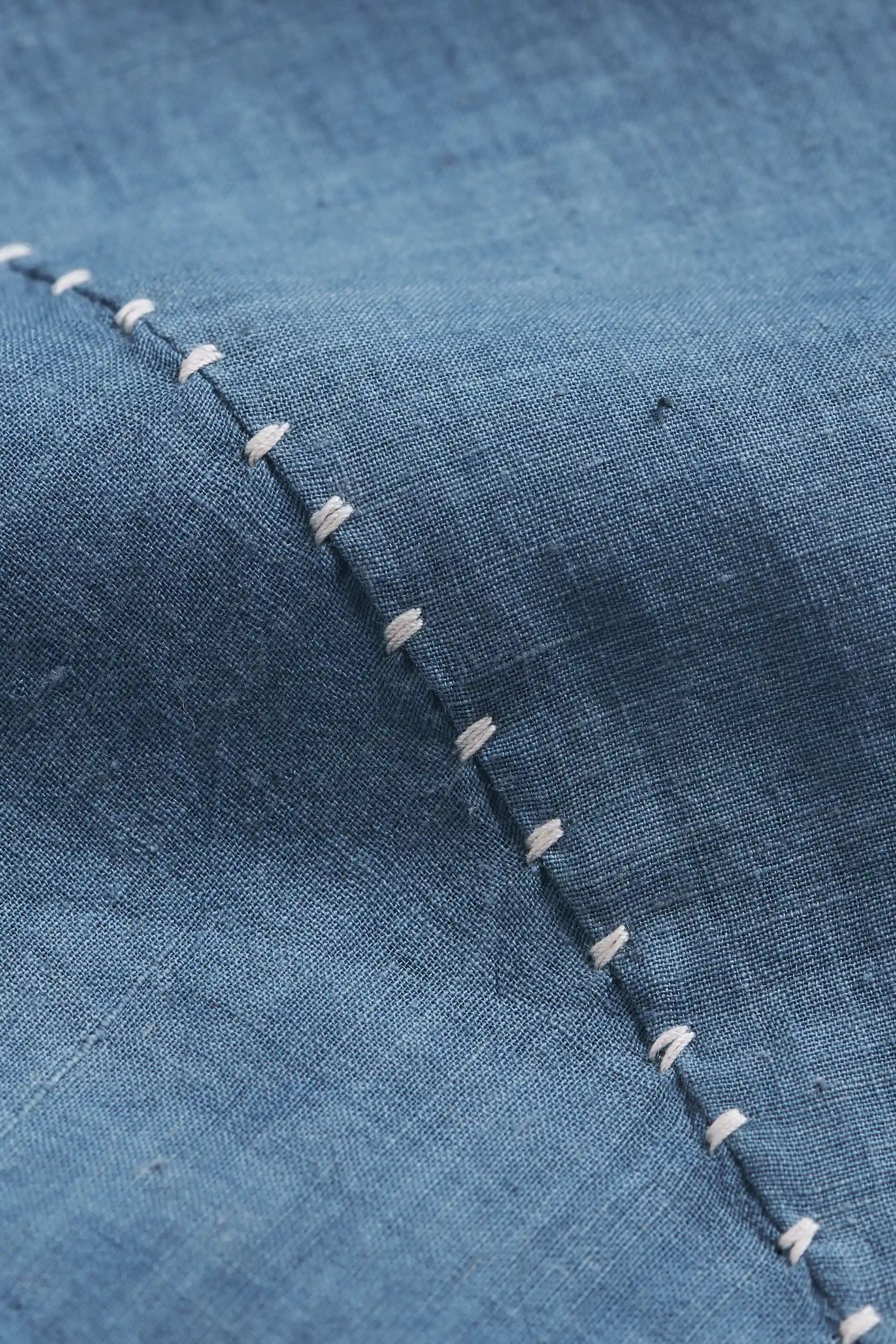 Close-up of blue fabric with hand detailing