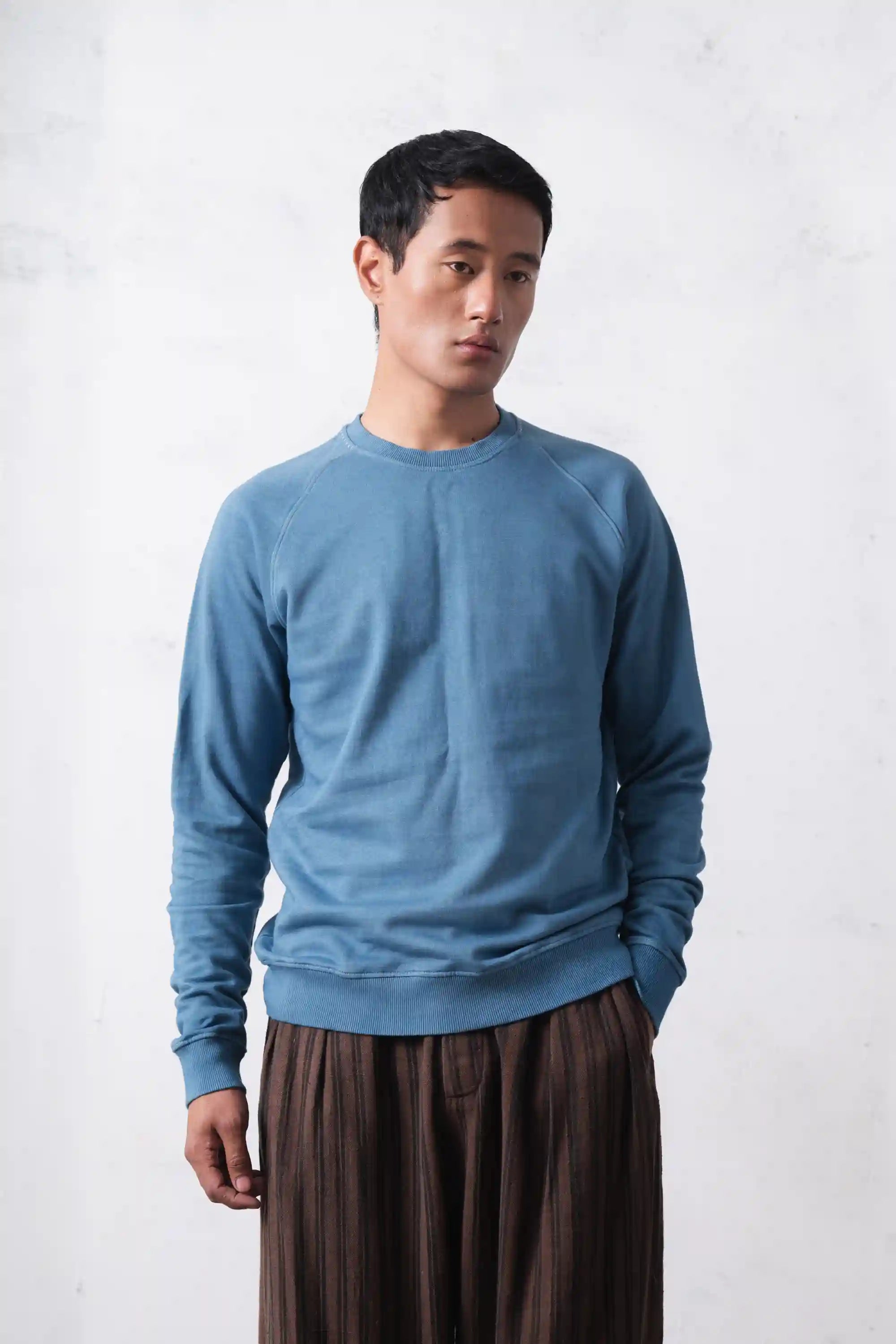 A man wearing powder blue sweatshirt