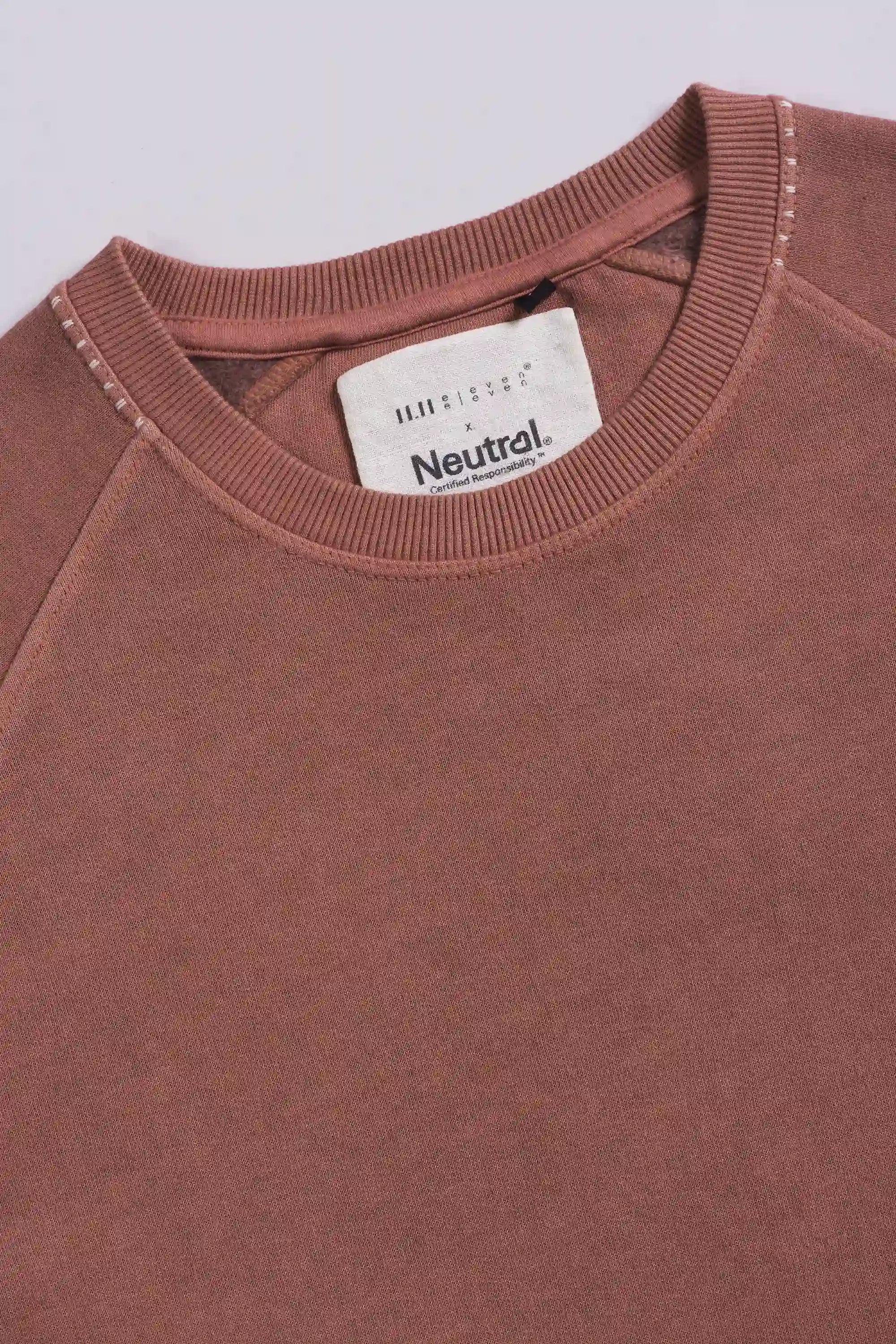 Close-up of a sweatshirt with a brand label on a light grey background