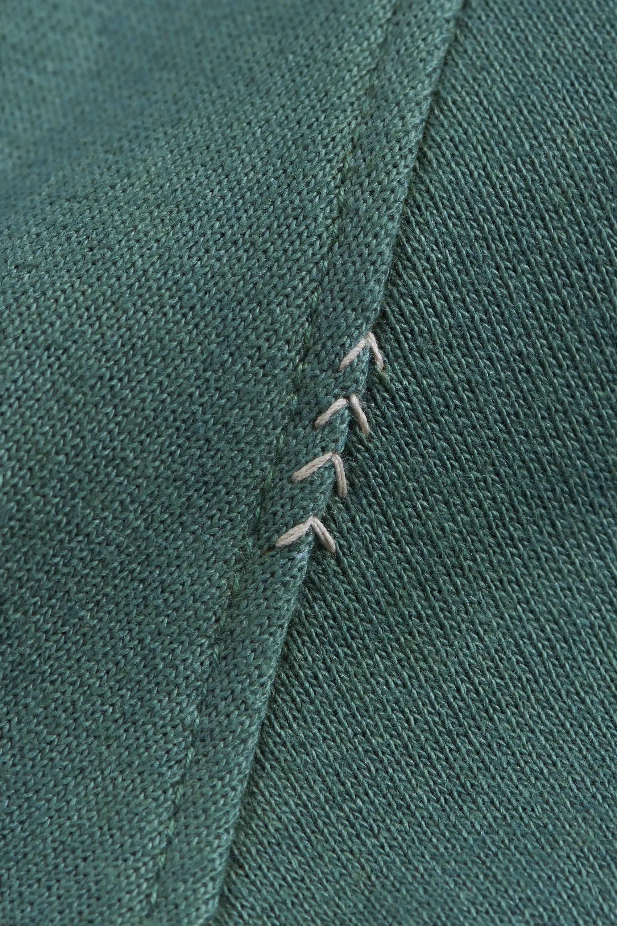 Close-up of green fabric with hand detailing