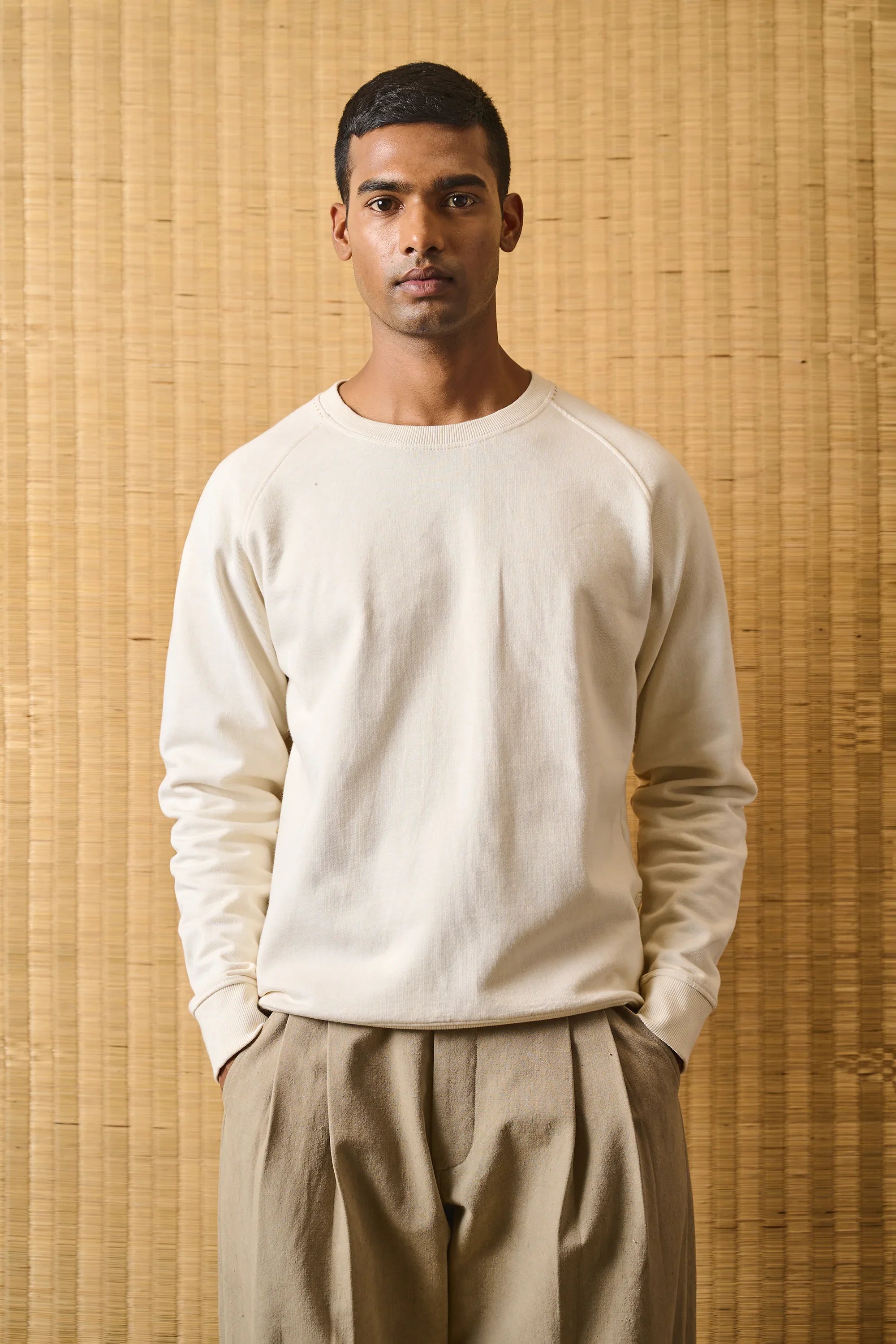 A man wearing ecru sweatshirt