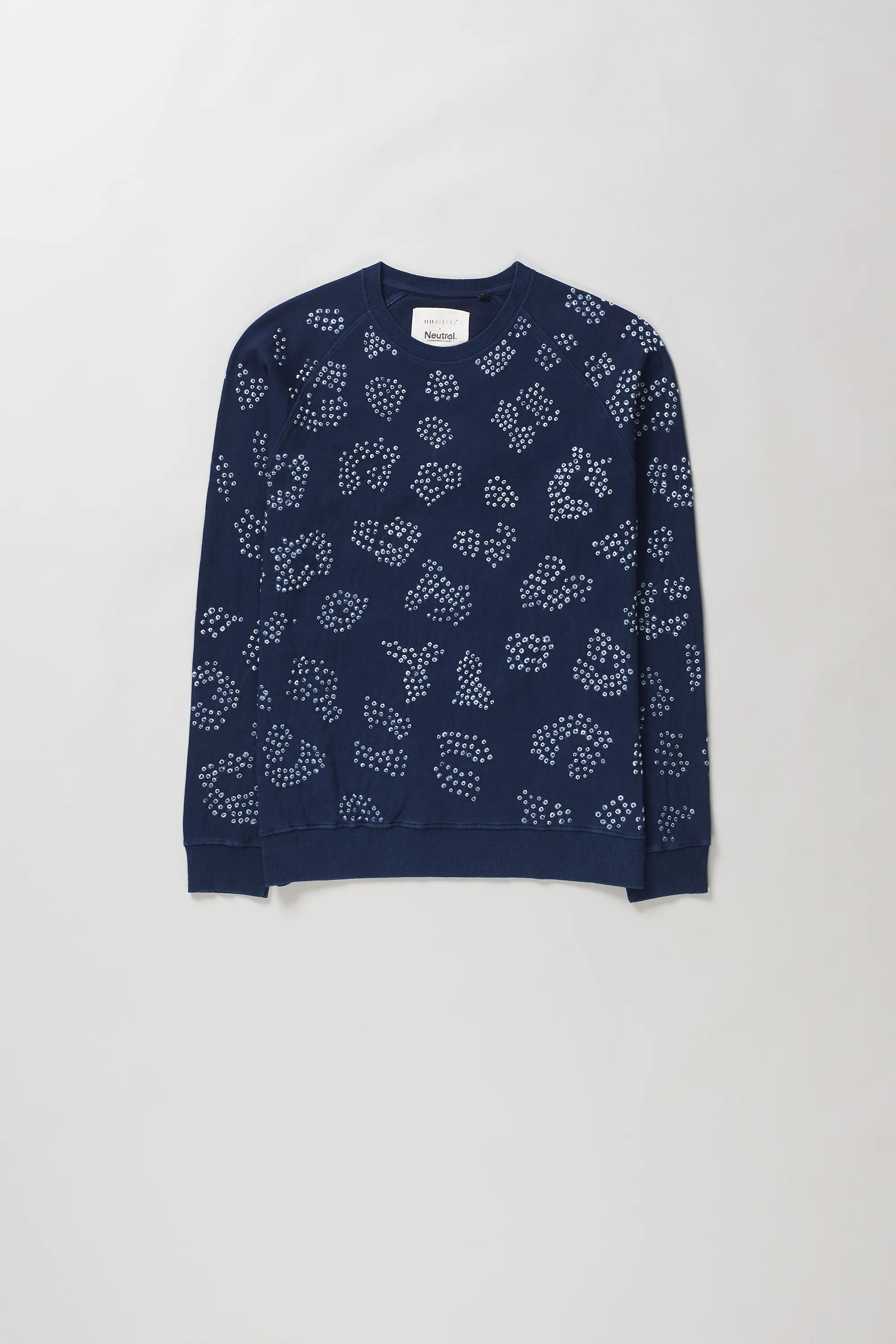 Indigo crewneck sweatshirt with an all-over white dotted abstract pattern bandhani, laid flat against a light grey background.