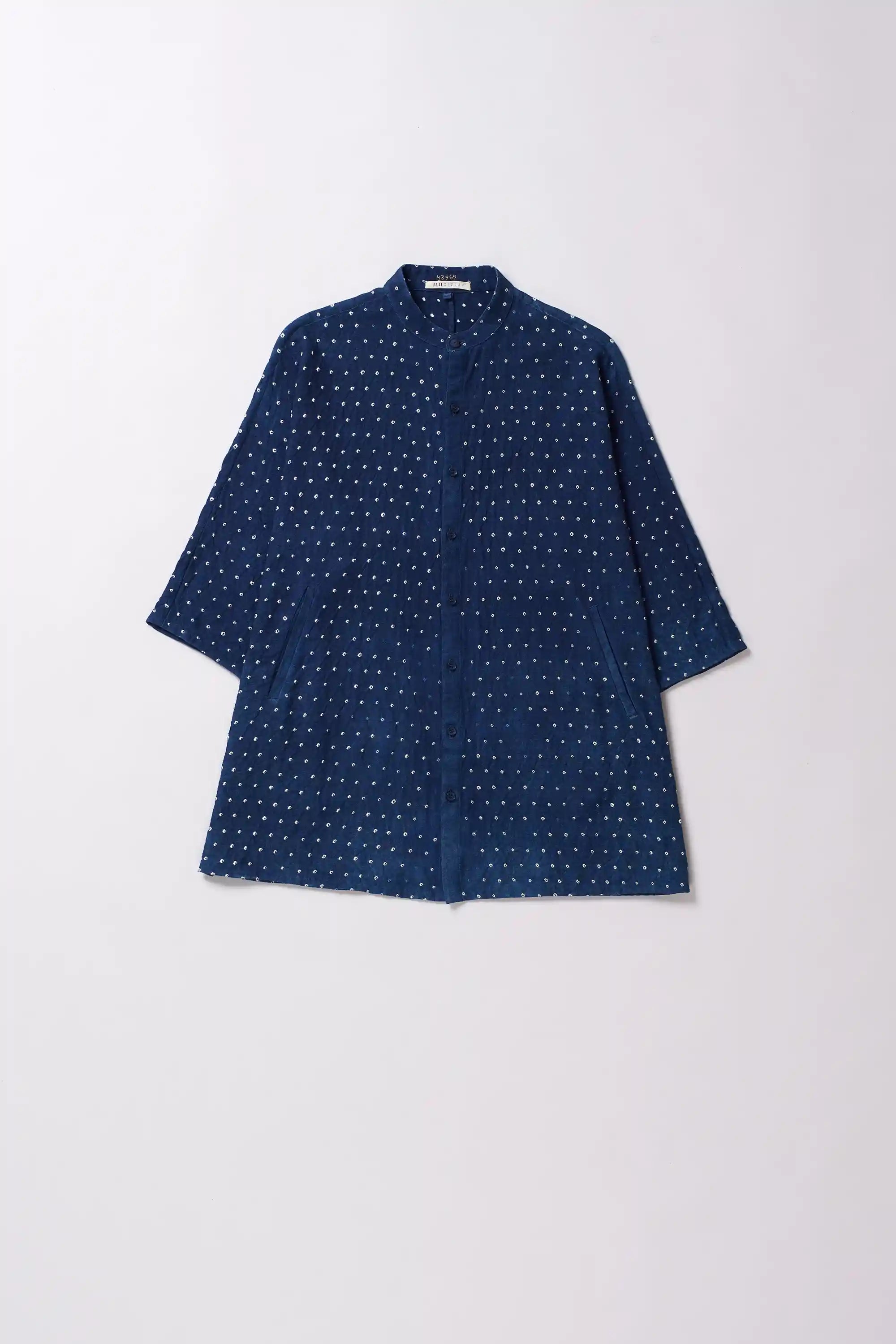Blue bandhani shirt on a light grey background