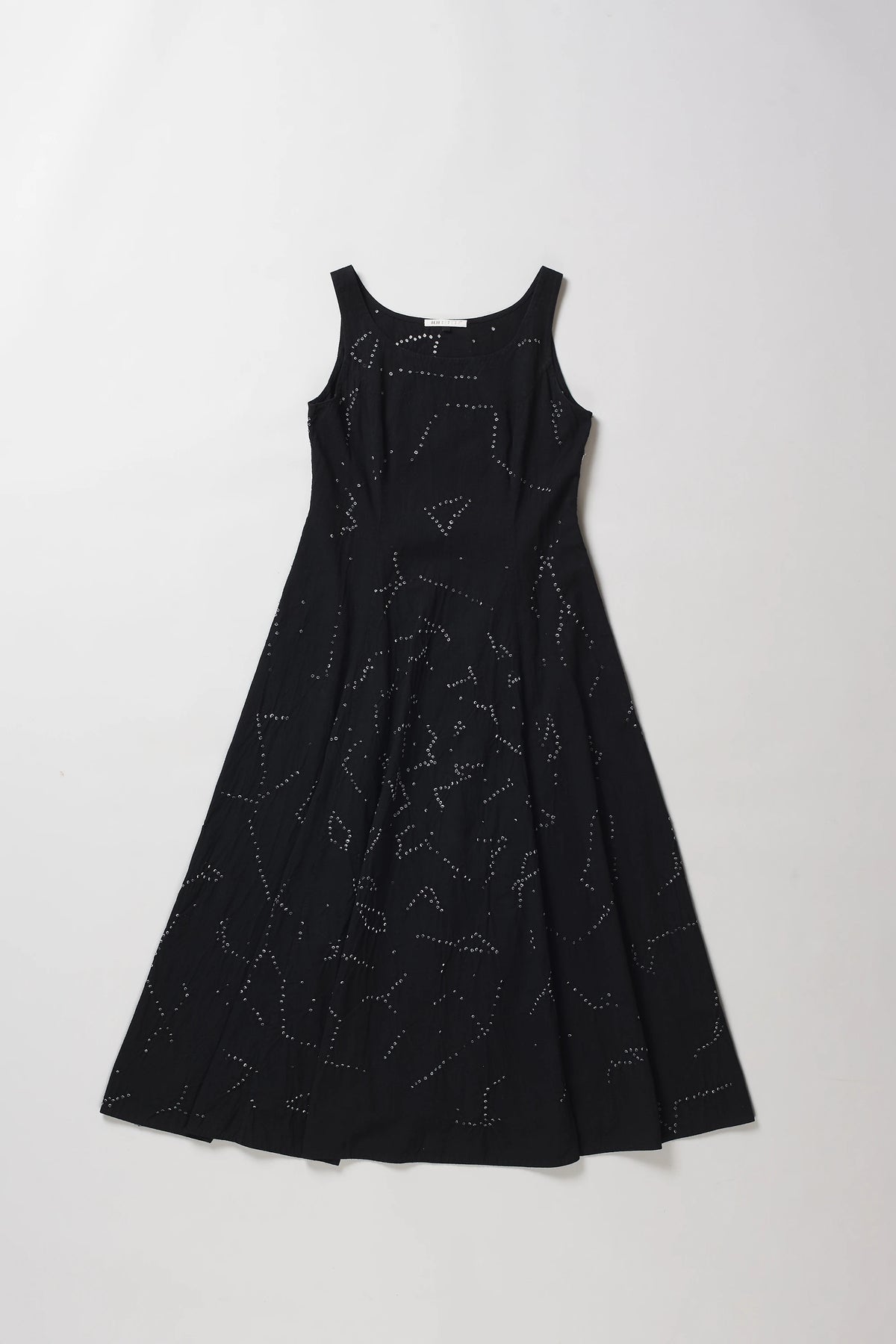 A sleeveless black A-line dress with a shibori pattern, displayed flat against a light grey background.