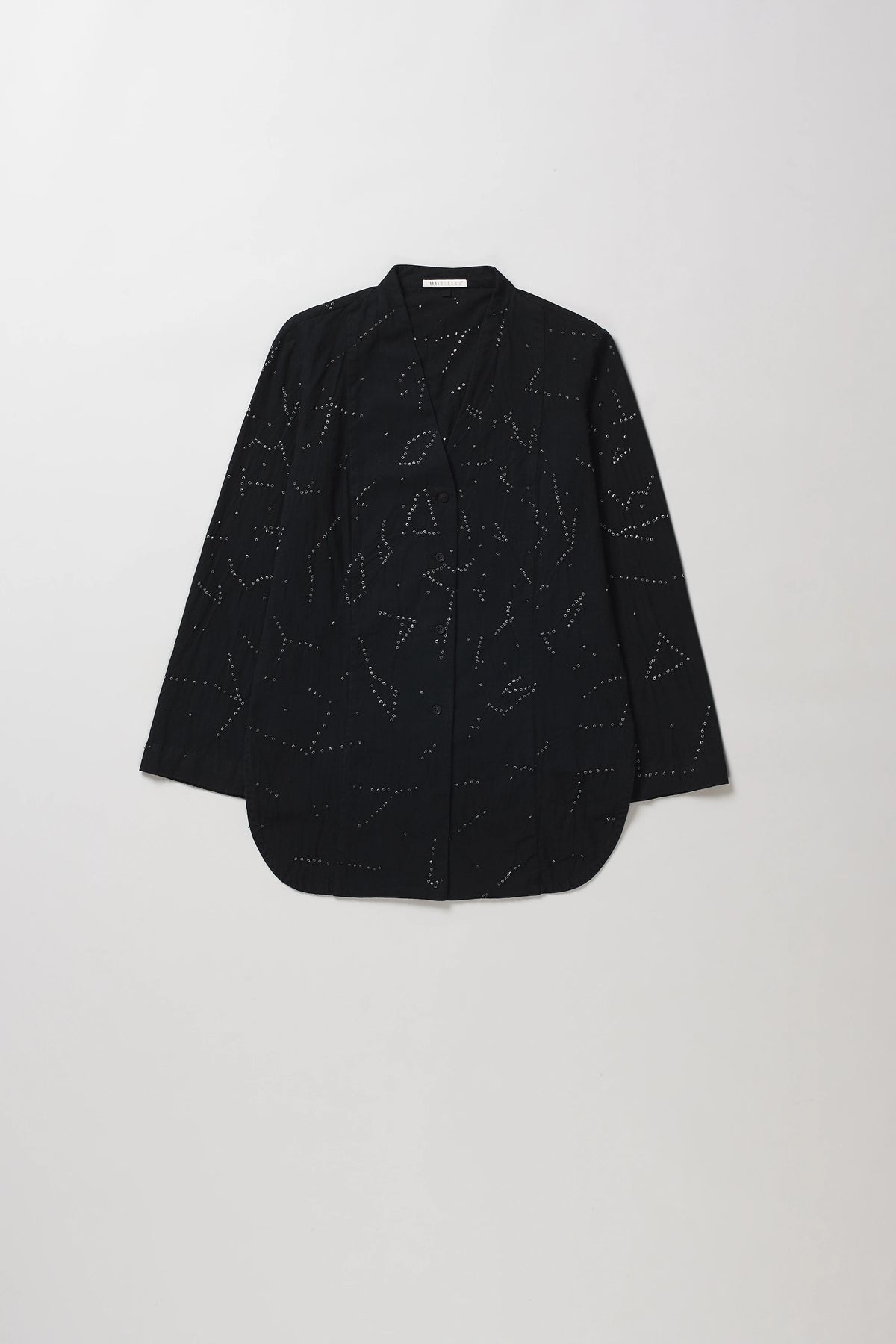 A black long-sleeve button-up shirt with an all-over abstract dotted line geometric pattern, laid flat against a light grey background.