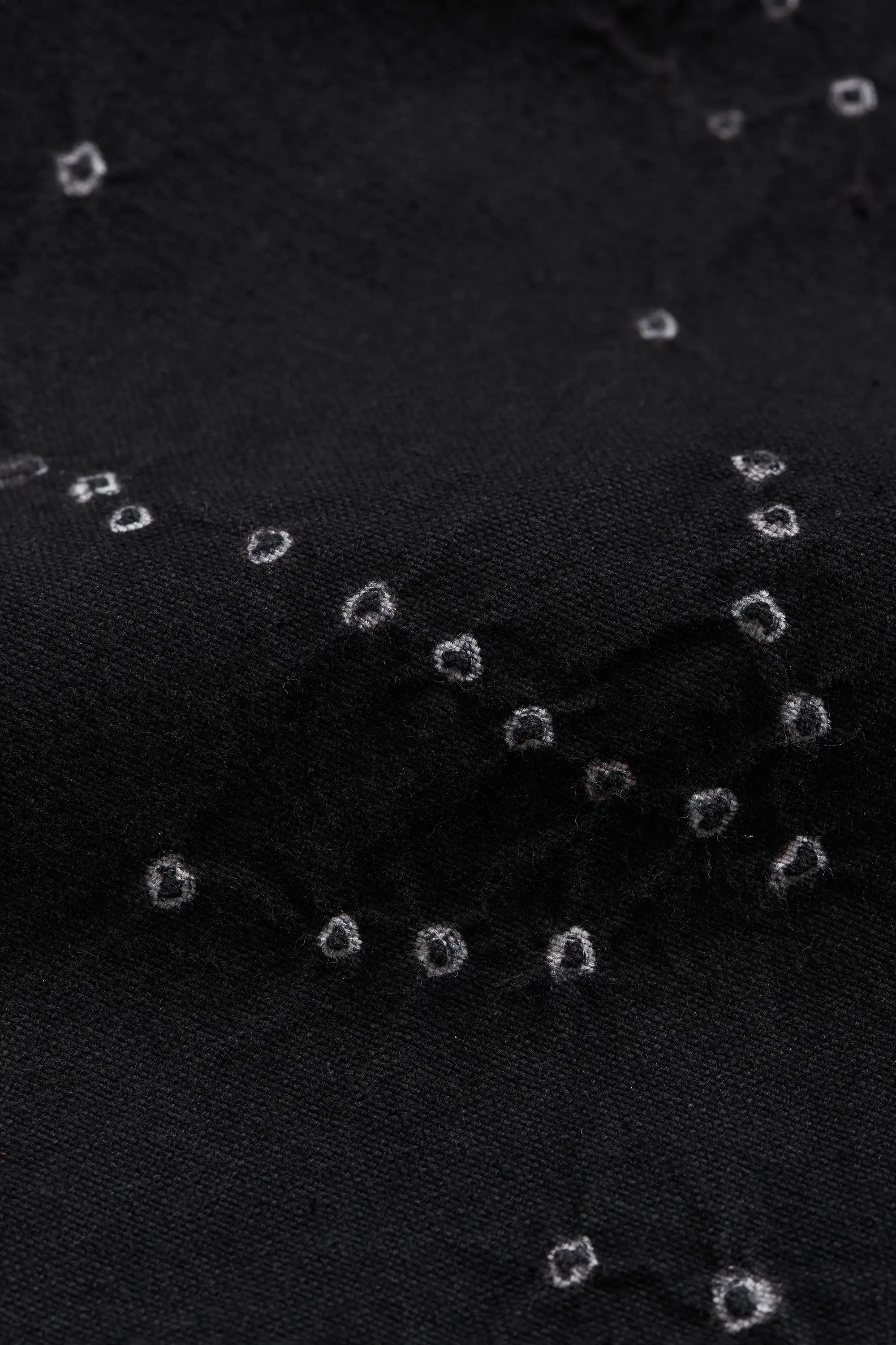 Close-up of black fabric with bandhani.