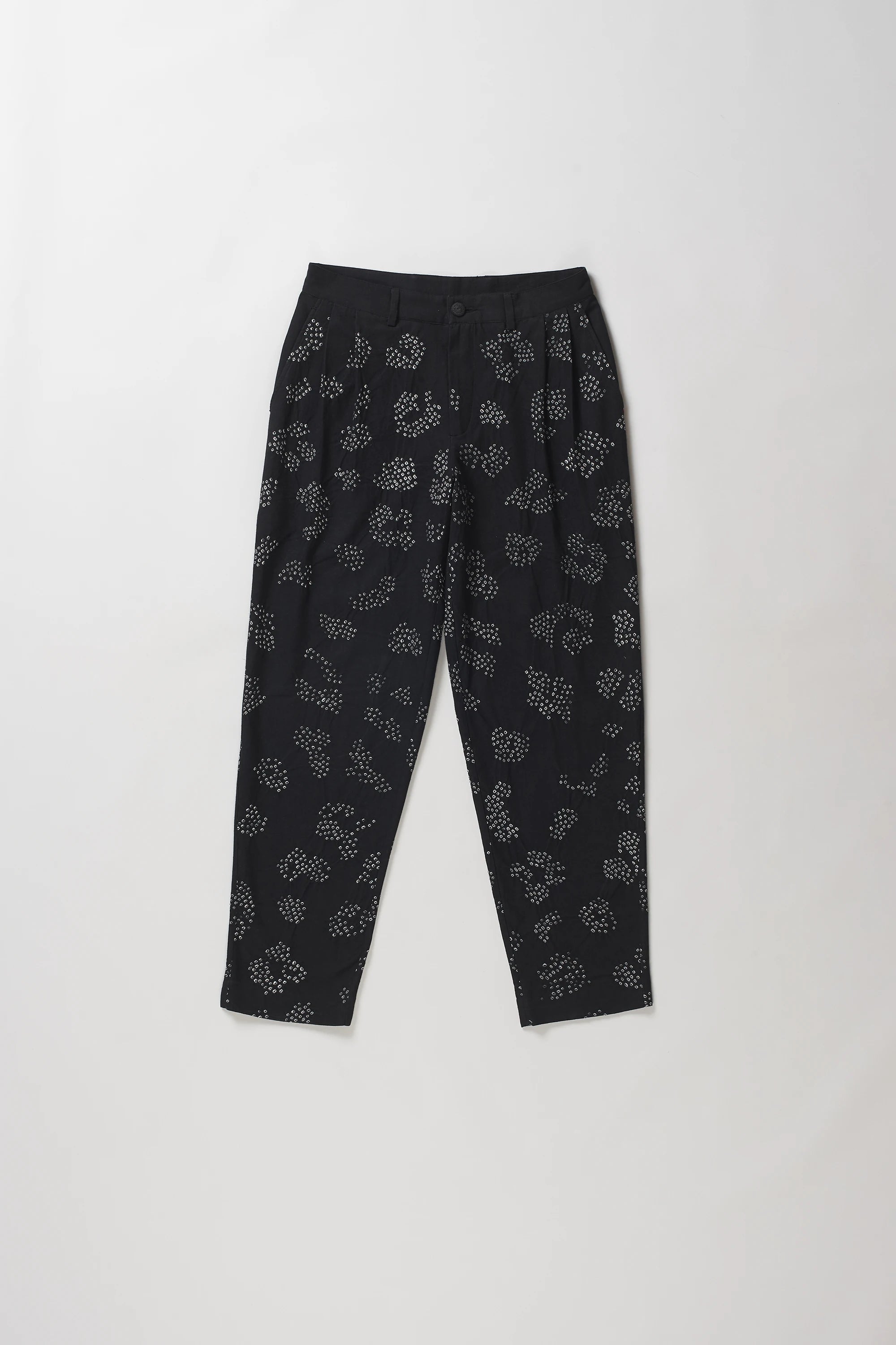Black trousers with a white floral bandhani, laid flat against a light grey background.