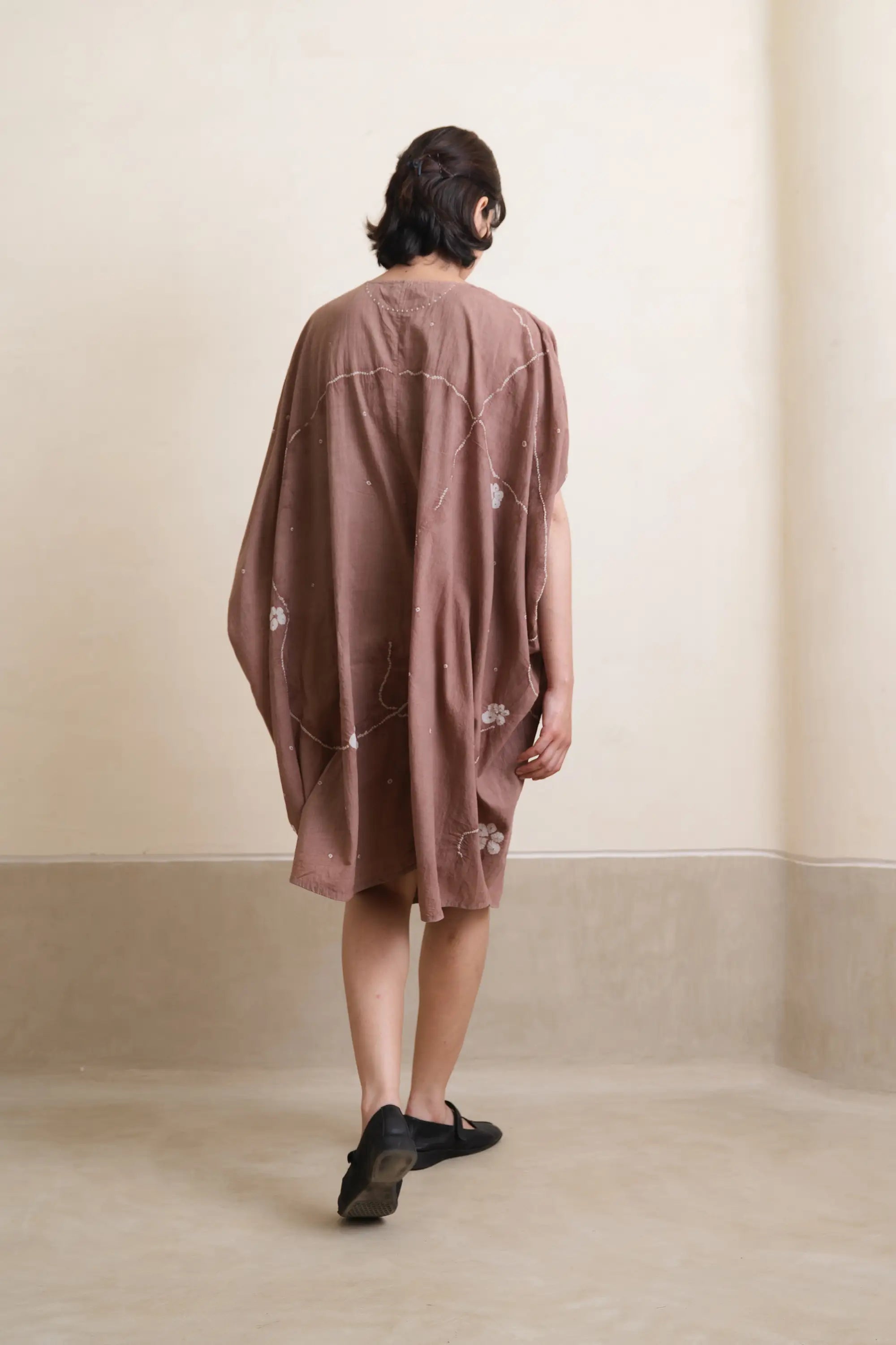 A back shot of woman wearing old rose dress