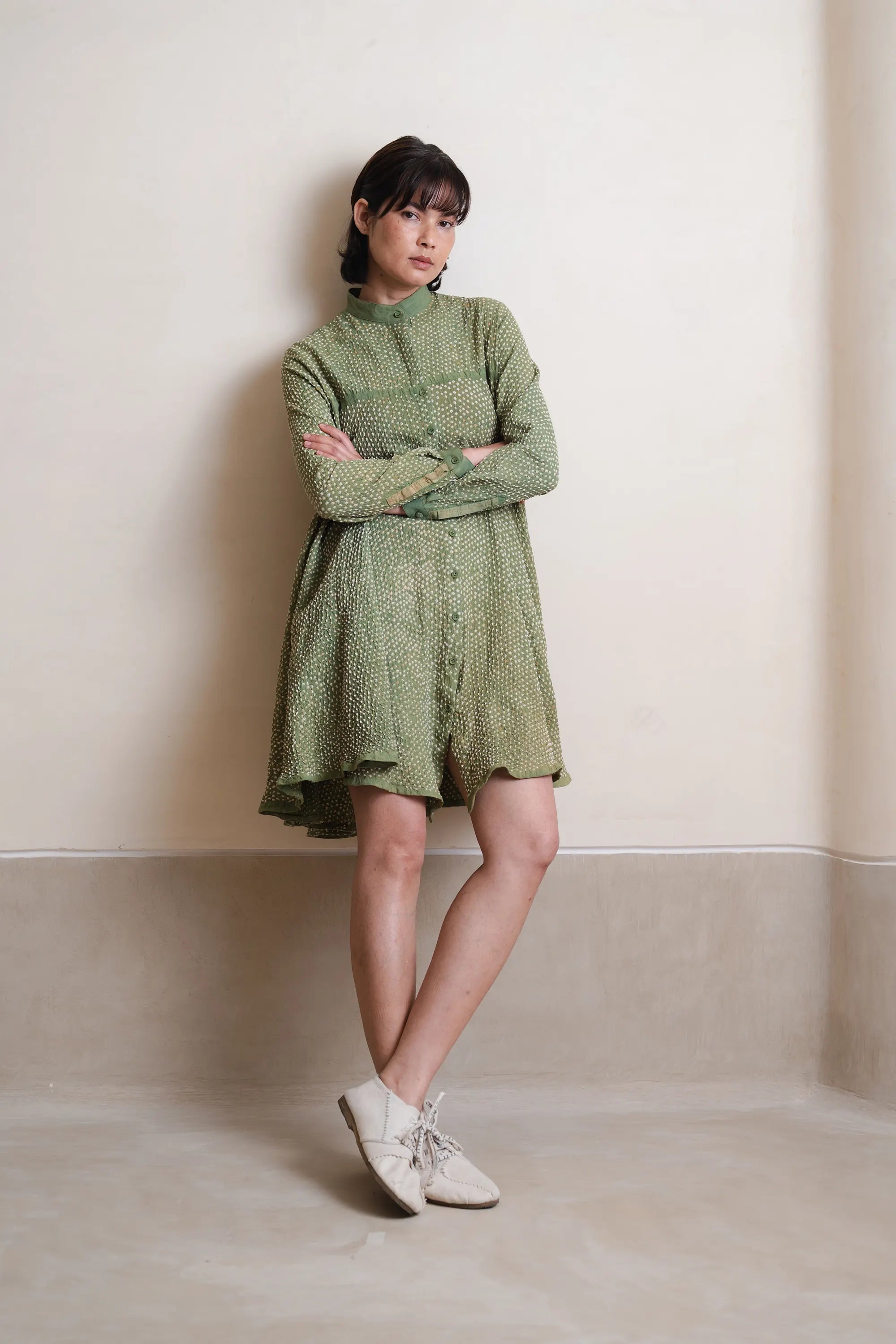 Model wearing a turf green dress ith grey background