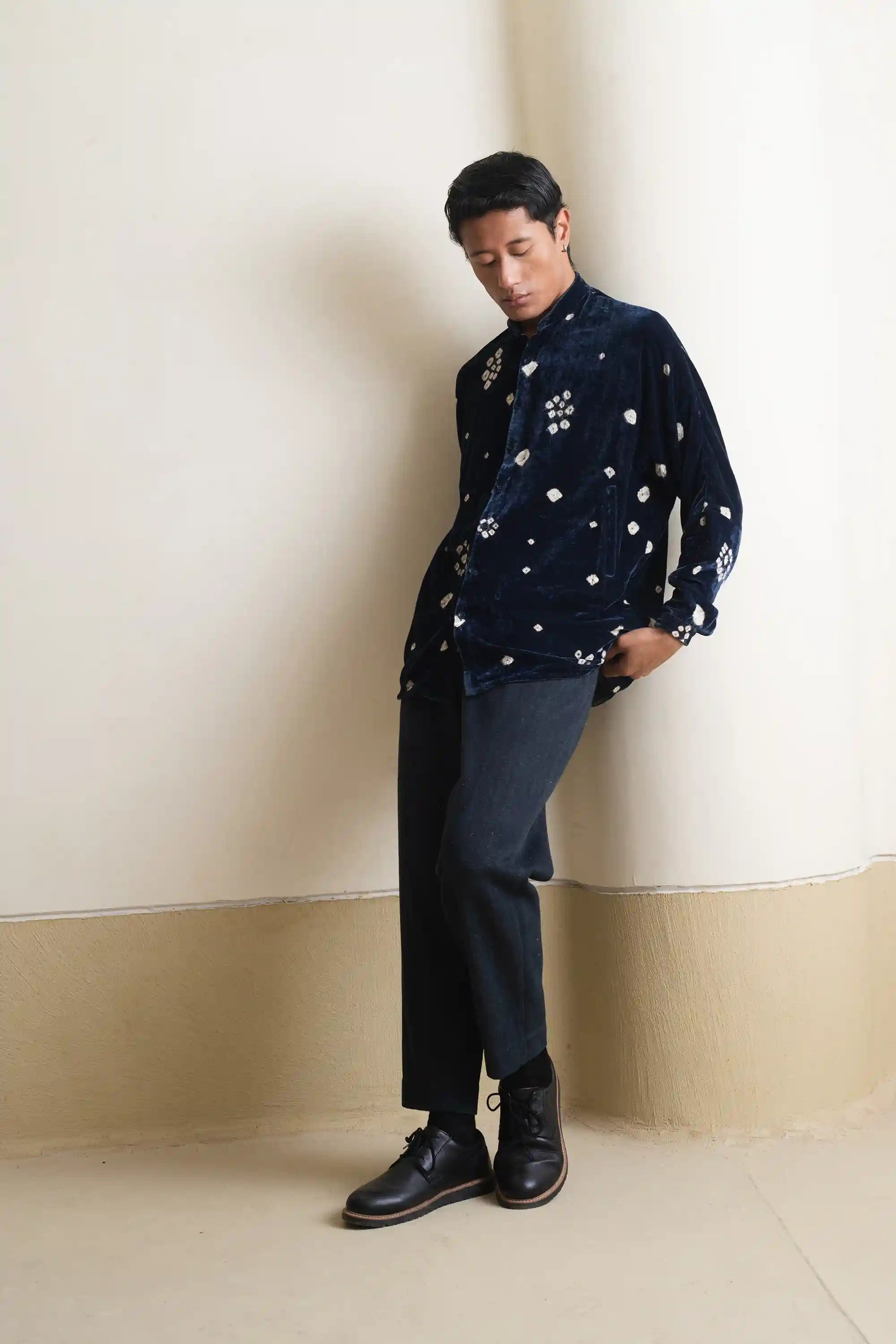 A side shot of a man wearing estate blue shirt