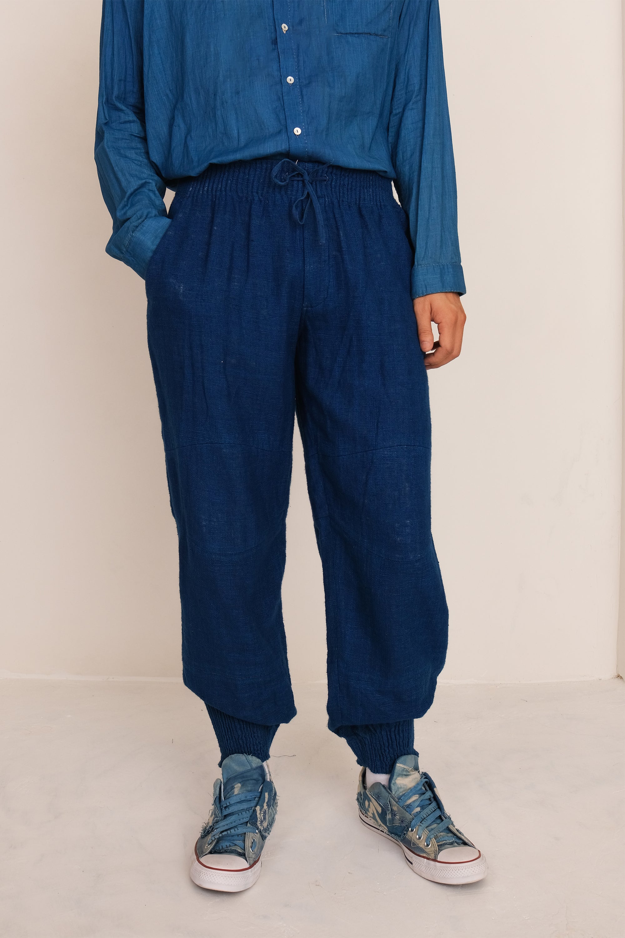 A man wearing medium indigo cotton pant with drawstring