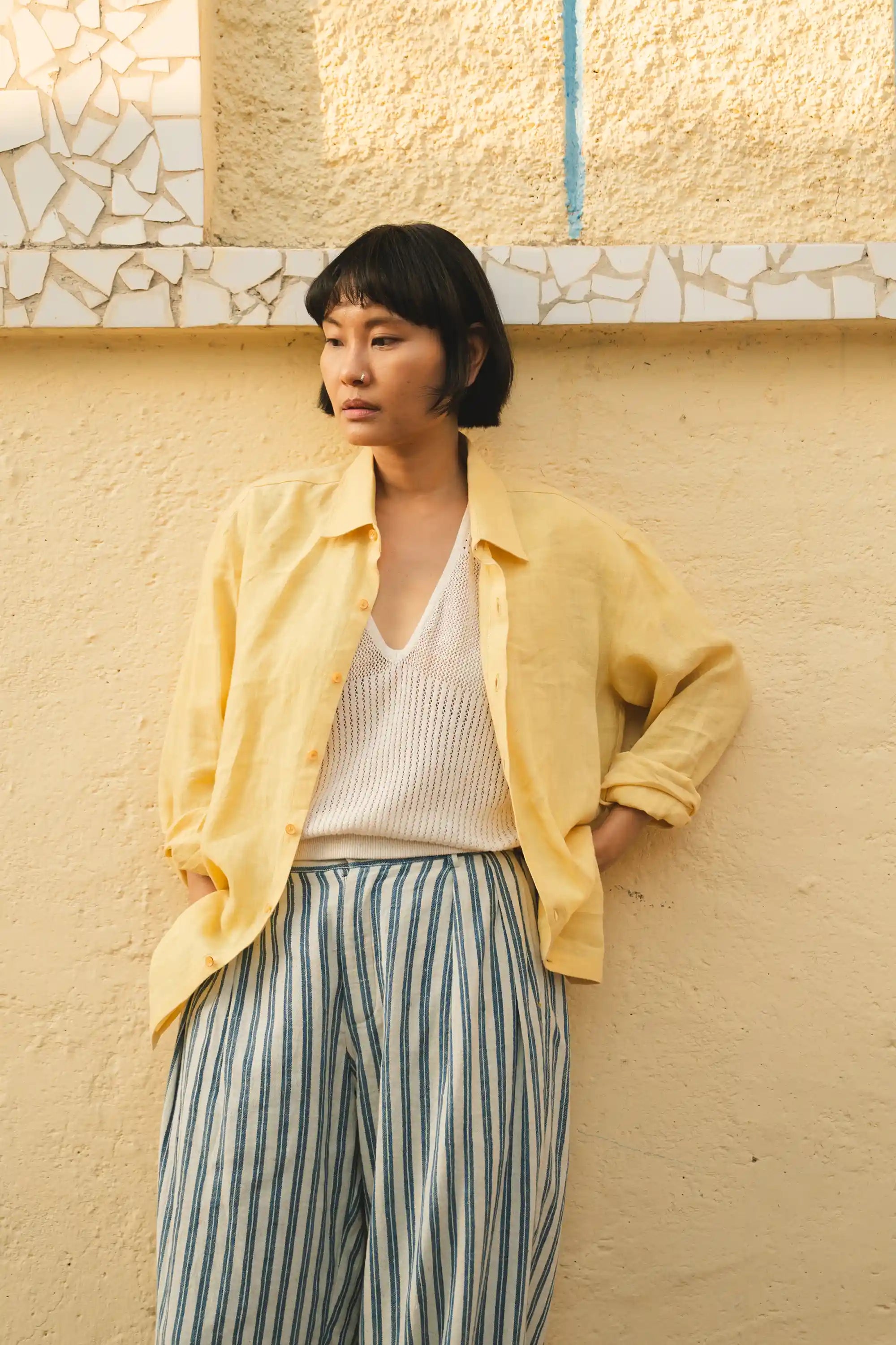 A woman wearing light yellow linen shirt