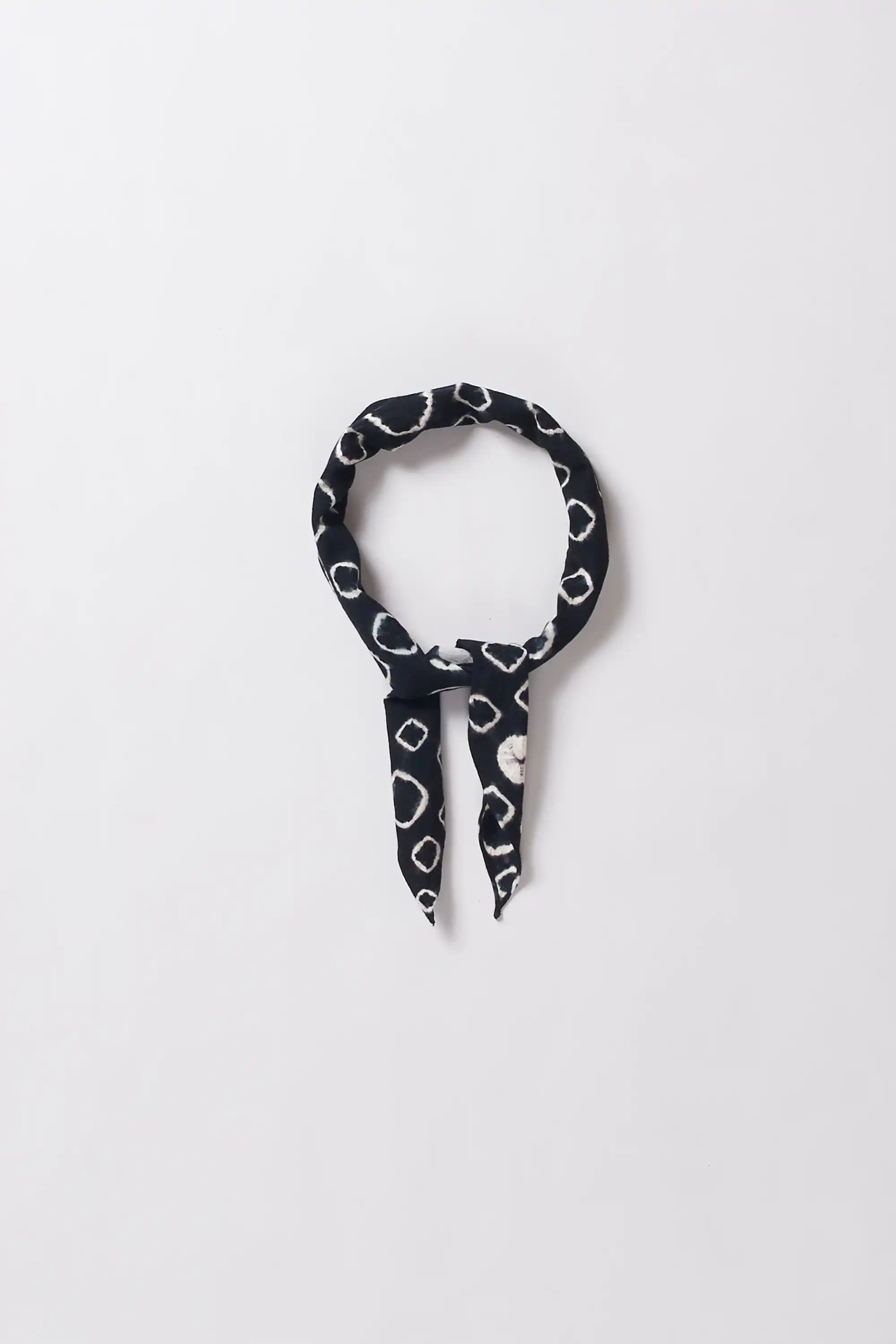 Black and white patterned hair tie on a light gray background