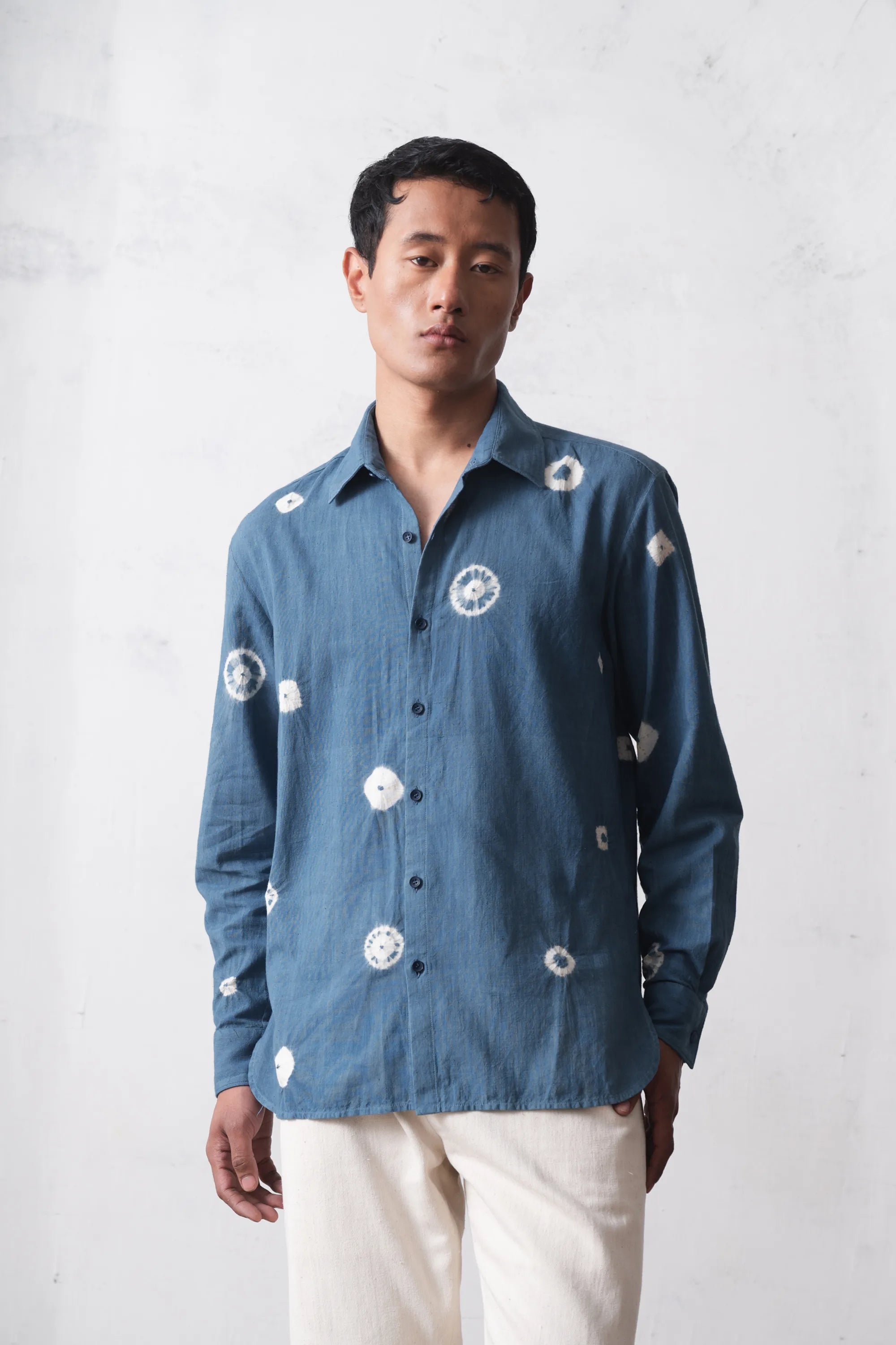 Man wearing a blue cotton shirt with bandhani on a light background background